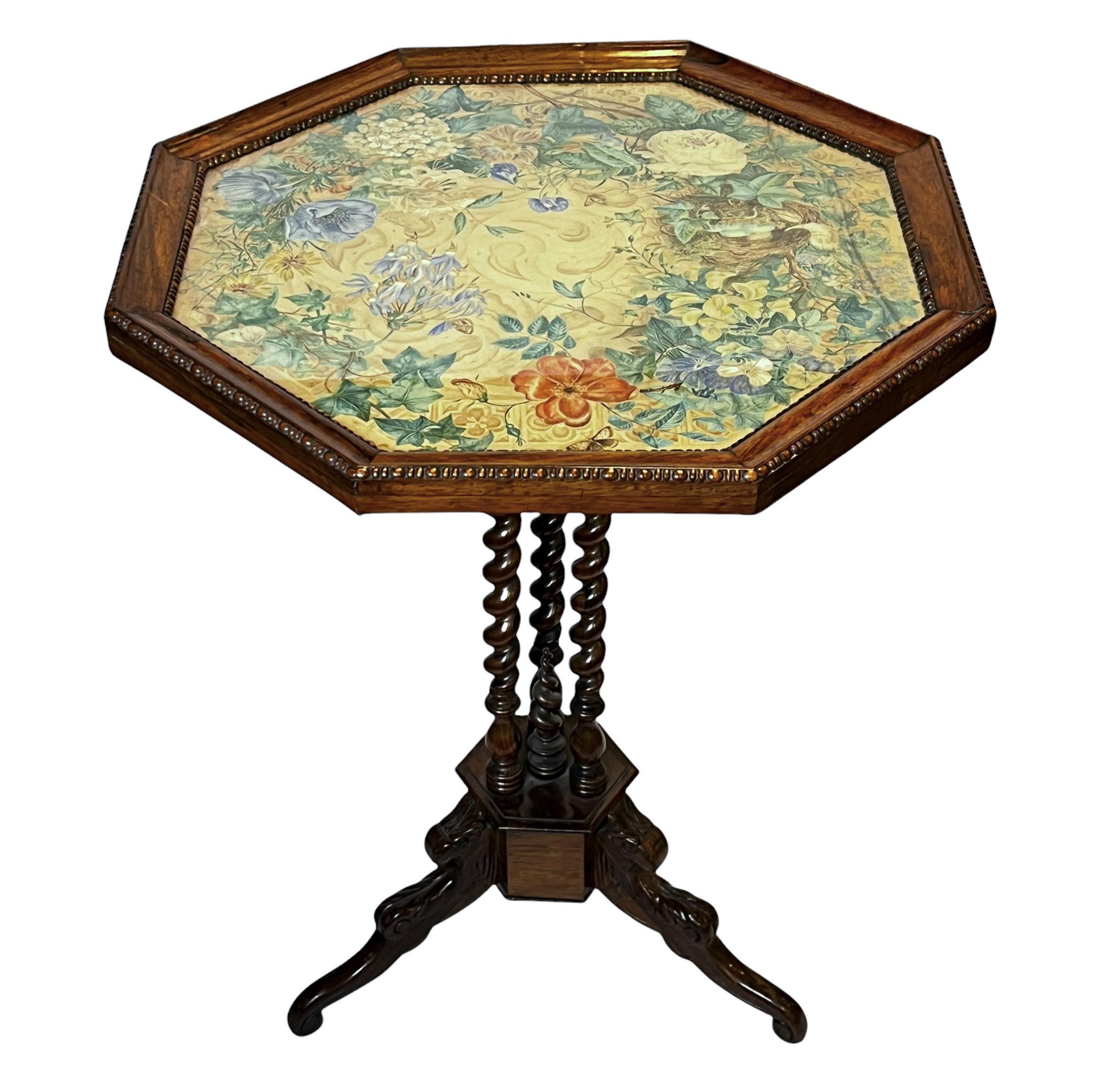 Our antique mahogany tilt-top tripod table with octagonal shaped top features a wonderful hand-painted floral top (apparently painted on fabric or paper) under glass top, with egg-and-dart carved molding around the perimeter, with original locking