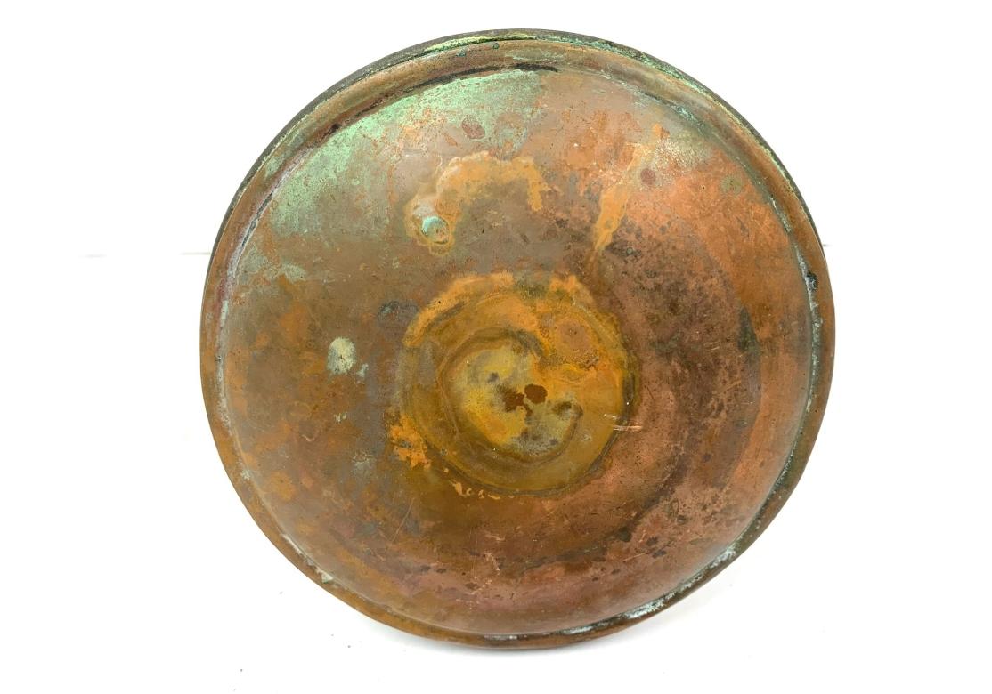 An antique copper mold featuring a prominent grape cluster design, likely used for making desserts like jelly, pudding, or cakes. The two piece mold with a domed bottom, deep reeded sides, ring pull with heart shaped tab and remnants of tin