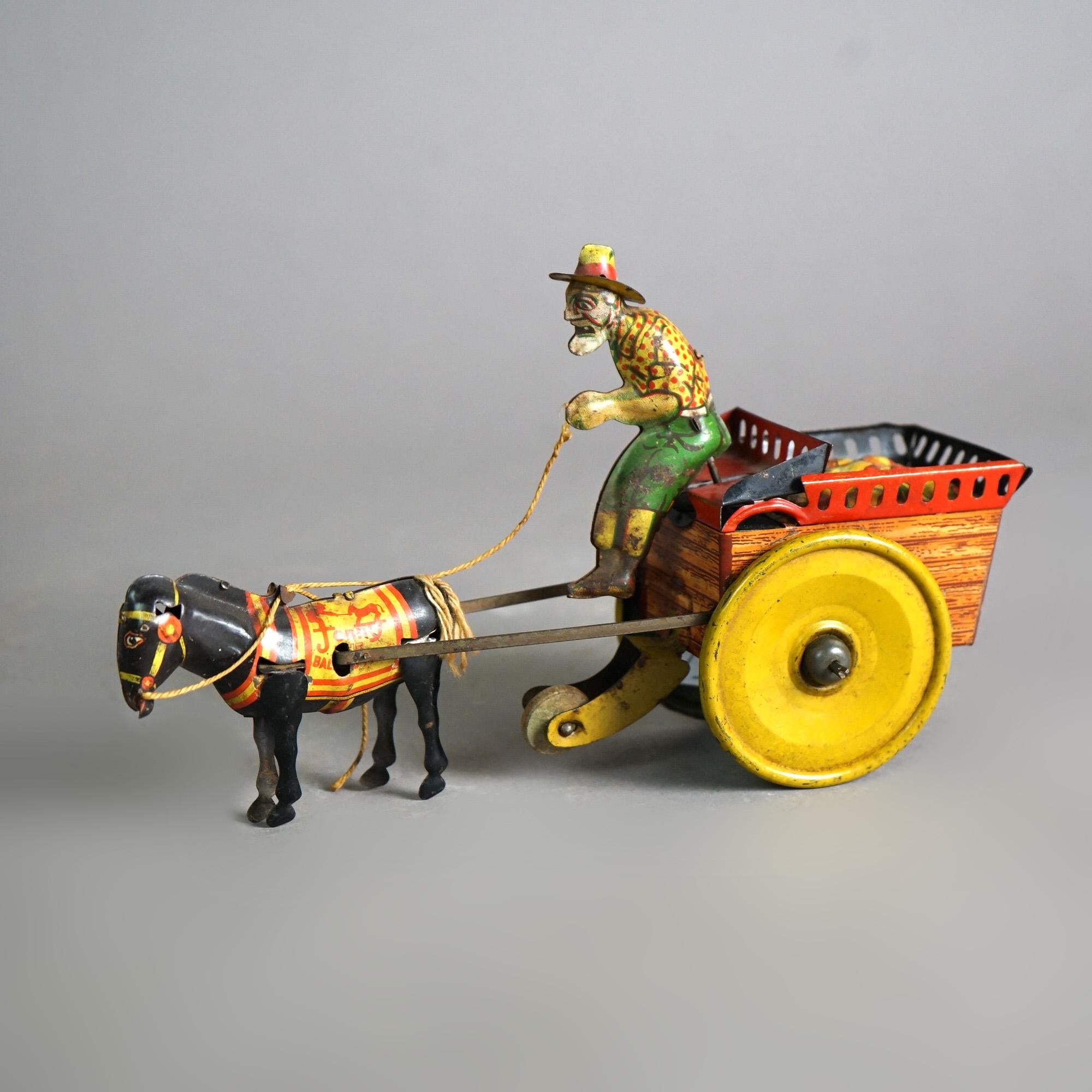 An antique wind up toy by The Ferdinand Strauss Corp. offers painted tin plate construction and depicts a mule drawn cart with a man, circa 1920

Measures- 5.25''H x 3.25''W x 8.75''D