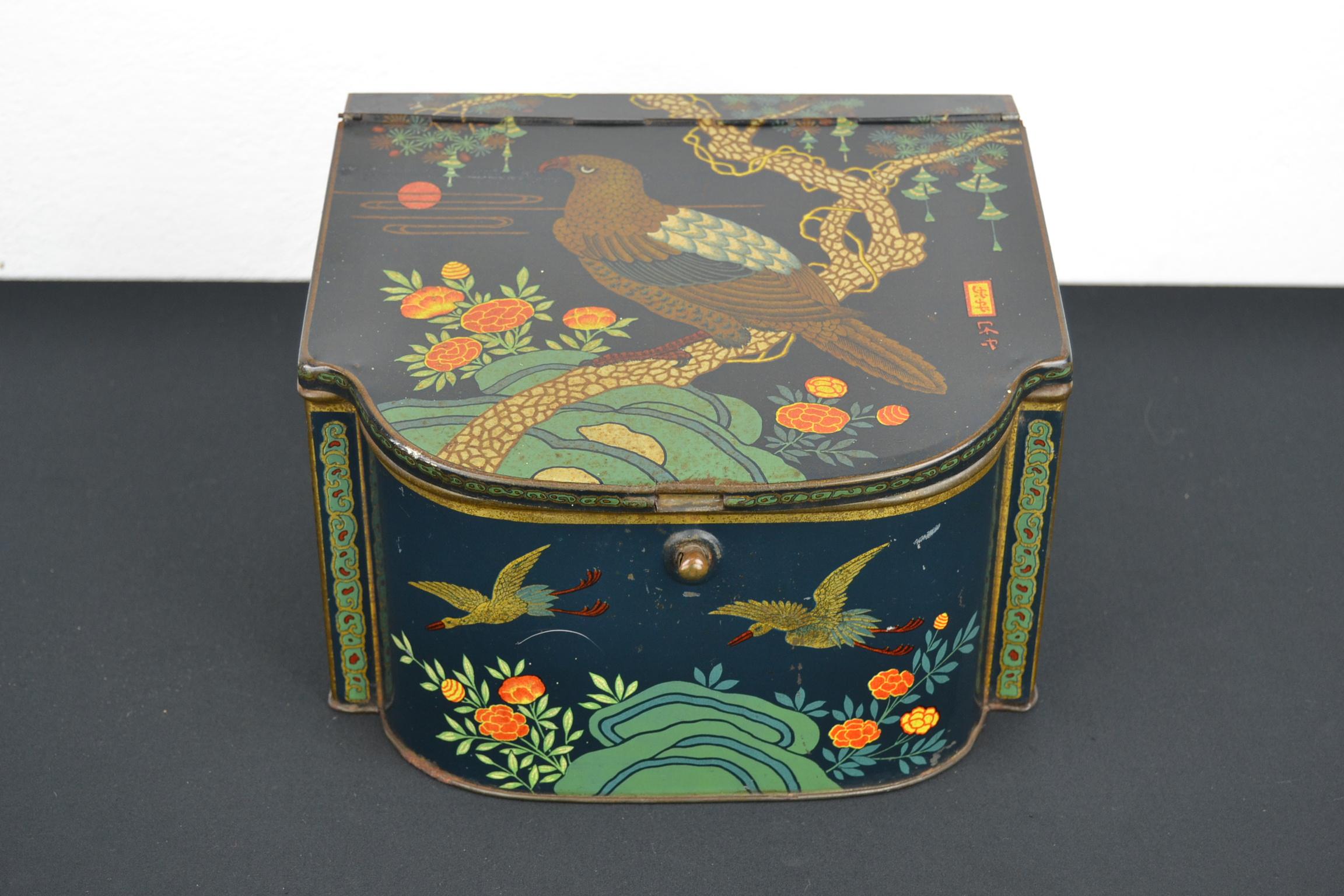 Antique tin Asian style with Asian birds.
This lithographic tin box was used to storage peppermint dragees and dates circa 1920s.
It was designed for the Dutch confectionary brand De Faam which made confectionery, peppermint and later also