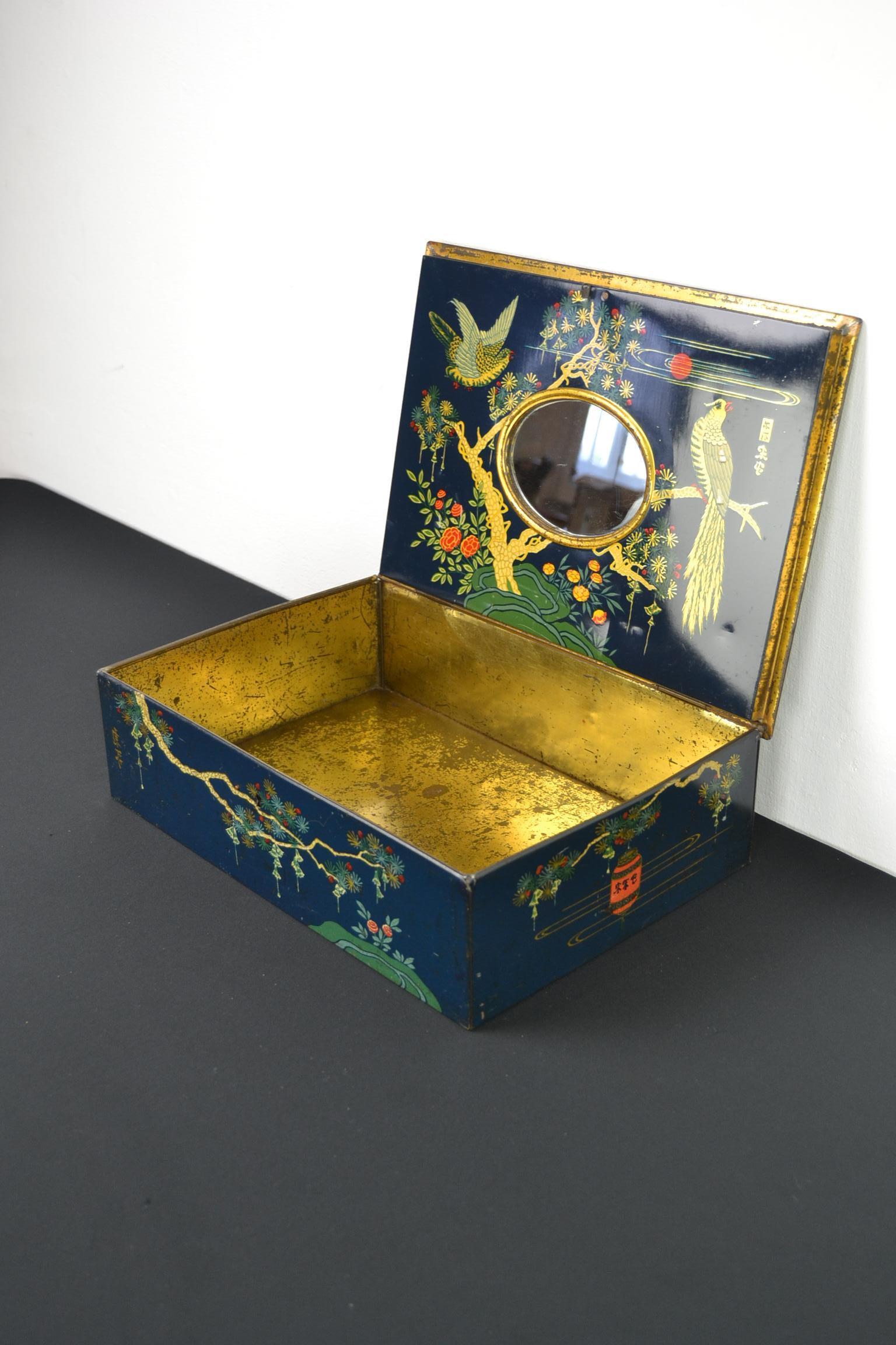 Large antique tin with mirror inside and lots of birds.
This lithographic tin box with mirror inside dates from the early 20th century.
It's a stylish and elegant antique metal storage tin
in dark blue color with a beautiful design in Asian