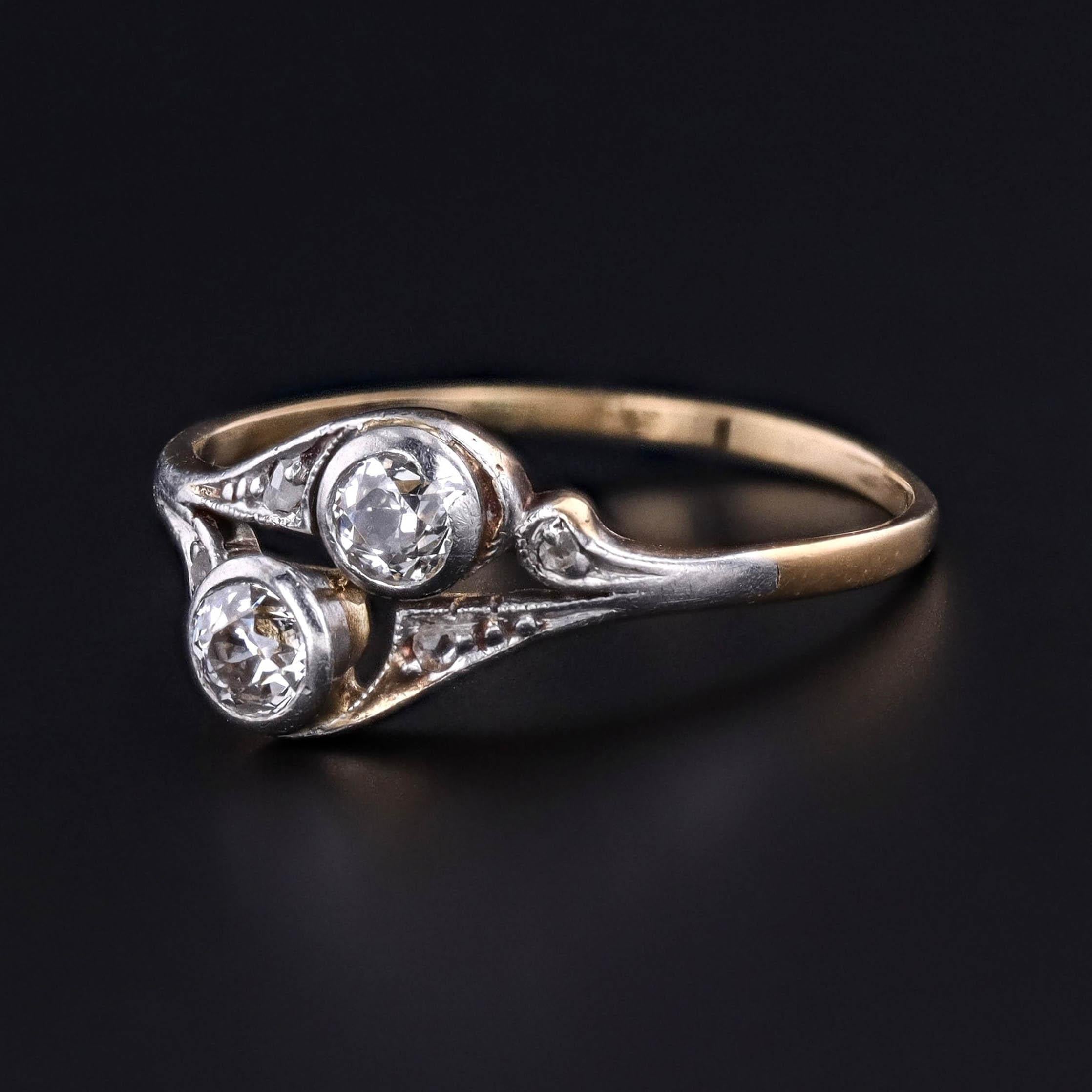 Bague ancienne datant de 1900-1910 comprenant deux diamants de taille européenne ancienne d'un poids total de 0,32 carat, sertis dans du platine surmonté d'or 14k.

La face de l'anneau mesure 0,3 pouces du nord au sud et est en très bon état.

La
