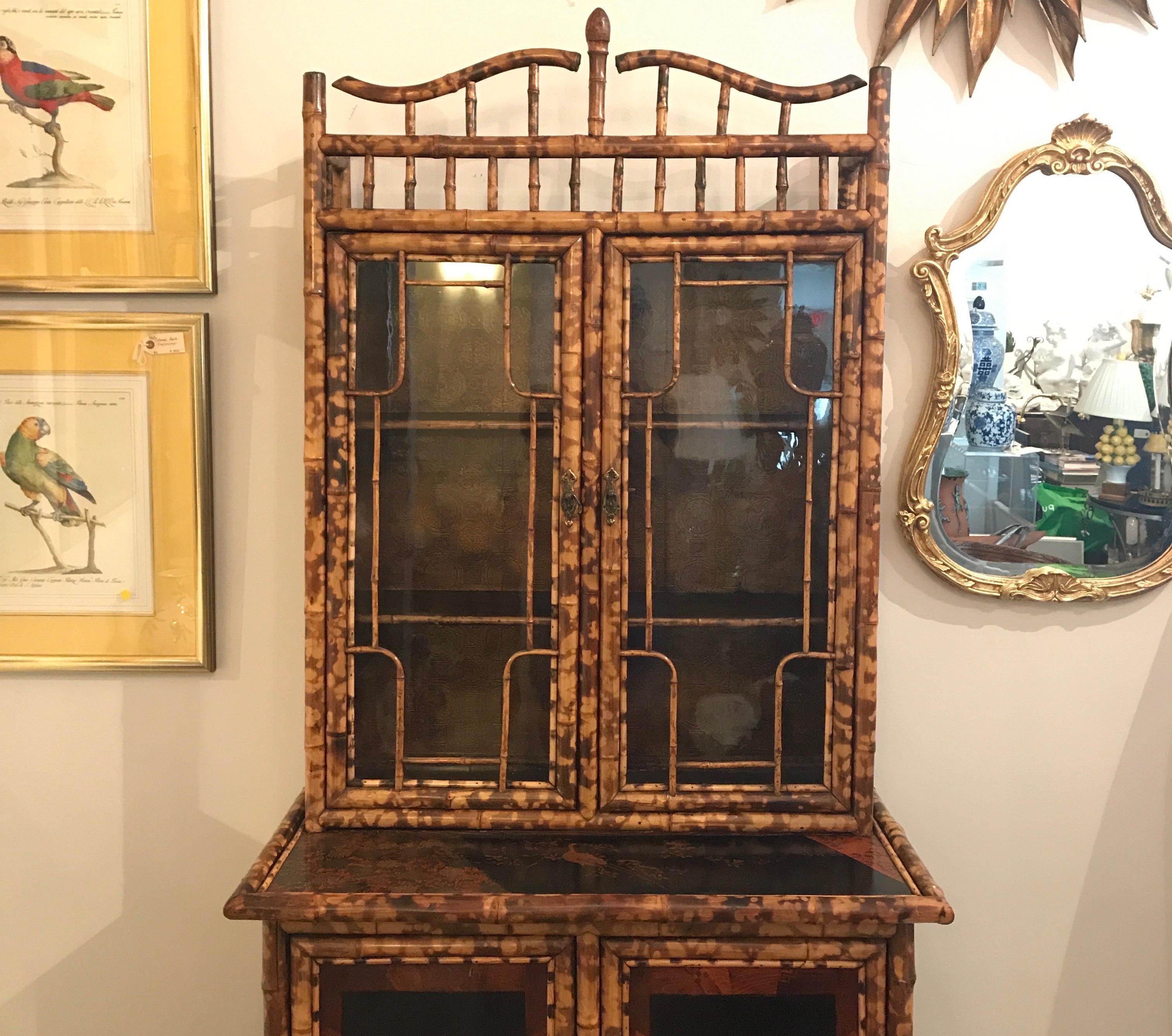 Antique burnt bamboo two part cabinet. Top has glass doors for display and bottom has hand painted doors for storage. This is an exquisite original piece.