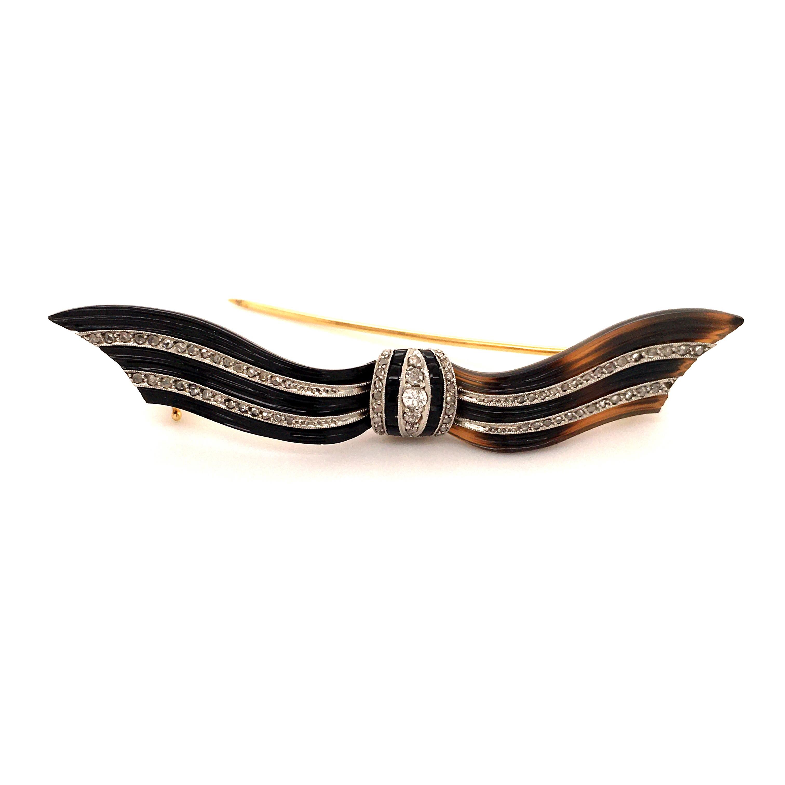 This delicate bow brooch is sculpted from tortoise shell, accented with old and rose cut diamonds and black chalcedony. Millegrain setting in platinum. Brooch fittings in 18 karat yellow gold. Very lovely item. 

Length: 6.5 cm / 2.56 Inches
Assay