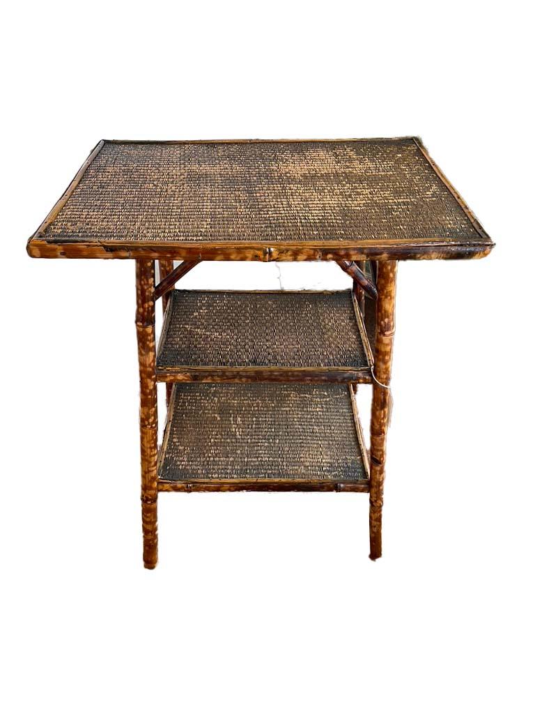 Victorian Aesthetic movement bamboo legged table with tiered rice mat tops on each shelf. This table is unusual in that it has three tiers.

Measures: 26” tall, 20 3/8” wide, 11 3/8” deep, middle shelf - 13 1/4” x 9 1/2” , bottom shelf - 14 3/4” x