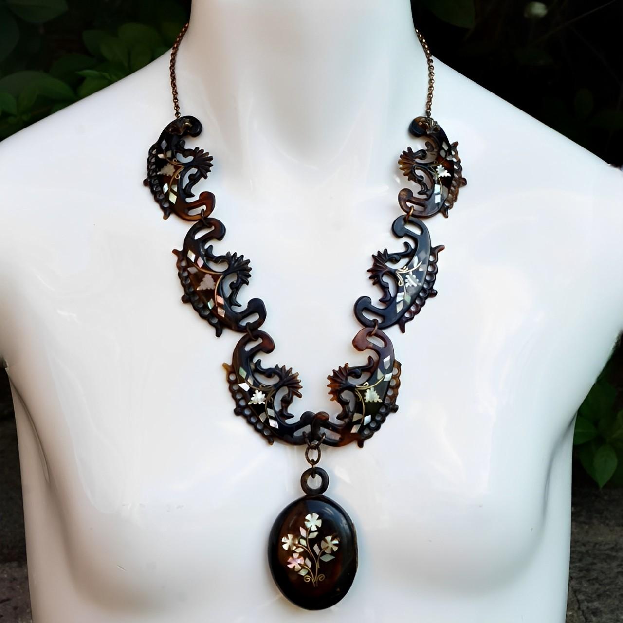 Antique Victorian tortoiseshell necklace and locket inlaid with gold and mother of pearl. This fine quality piece has the most beautiful piqué work, which has been done by hand. 

The necklace is length 55 cm / 21.6 inches. The tortoiseshell on the