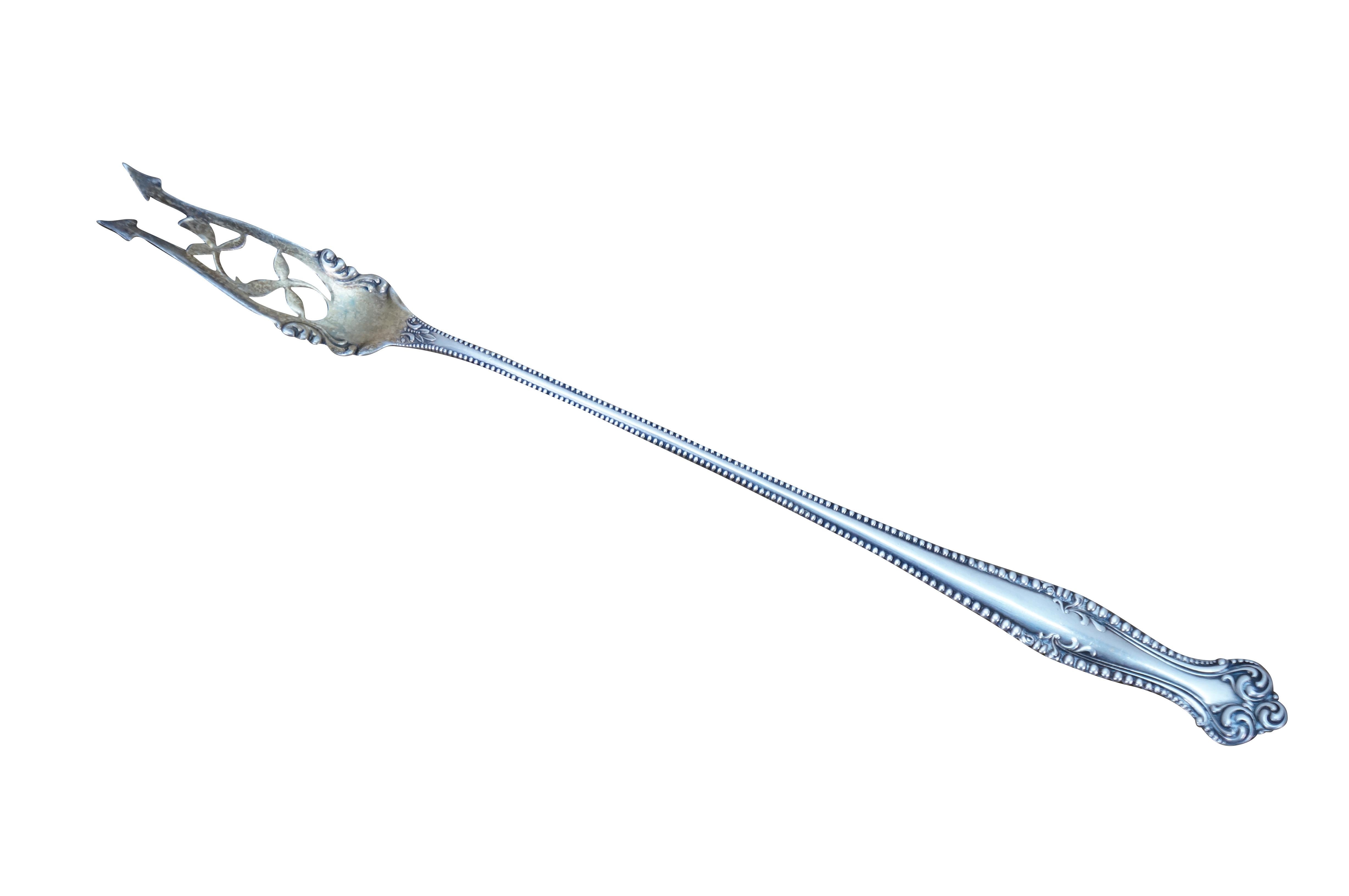 Fourchette à cornichon ancienne en argent 925/1000 du 20e siècle par Towle Silversmiths dans le modèle Canterbury. Le bord perlé est orné d'un feuillage et de feuilles entre les deux griffes en forme de trident. Poignée gravée du nom