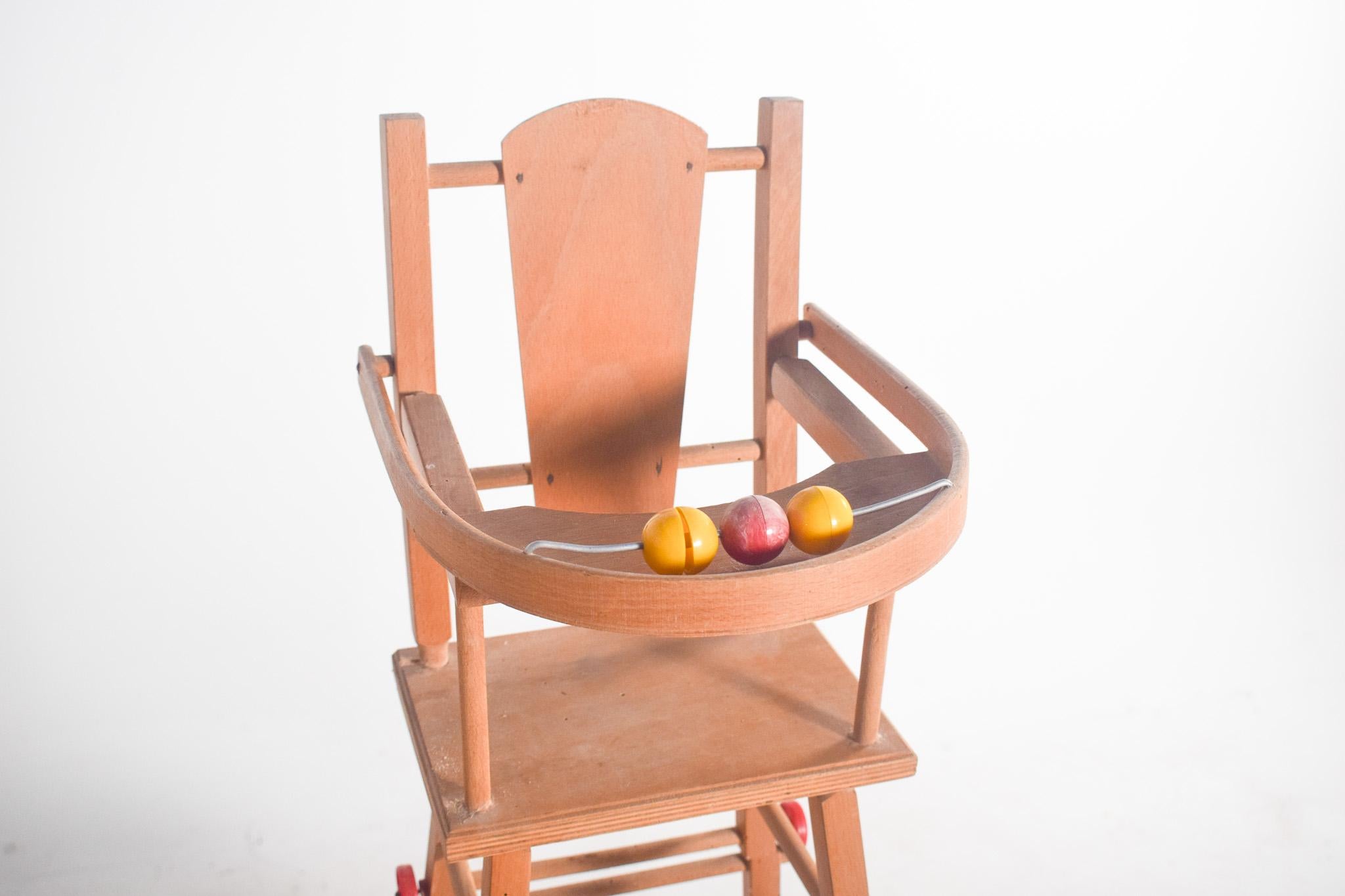 Chaise-jouet en bois. Conçu pour les jeunes enfants. La structure est en bois léger, avec un design simple et fonctionnel. Il est doté d'une assise surélevée et d'un dossier incurvé, offrant un soutien confortable. La table fixée à l'avant sert de