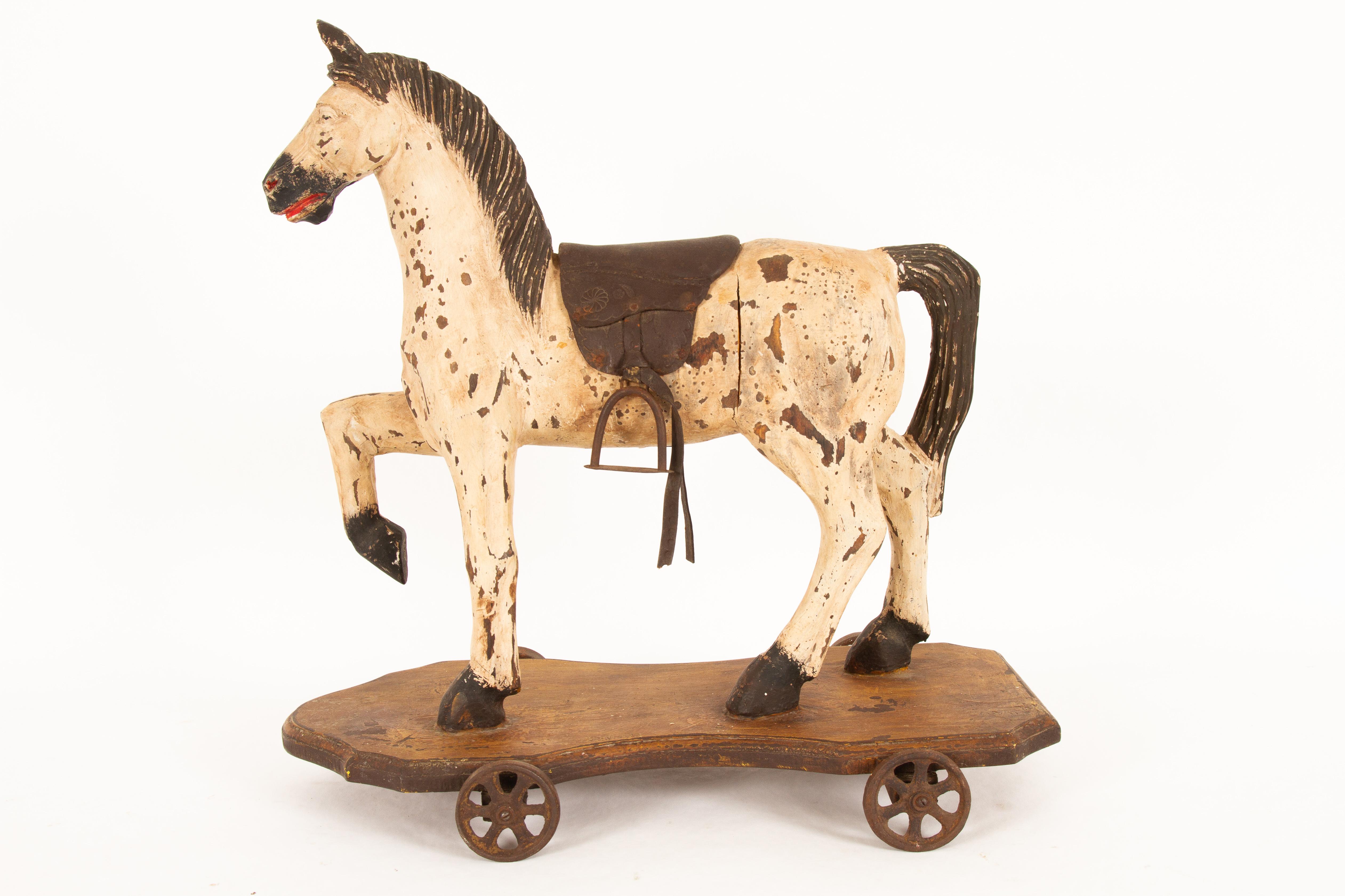 Beautiful and decorative toy horse. All original paint, saddle and wheels. Carved of solid wood and hand painted. Complete with saddle and stirrups. Rare condition. Scandinavian origin.