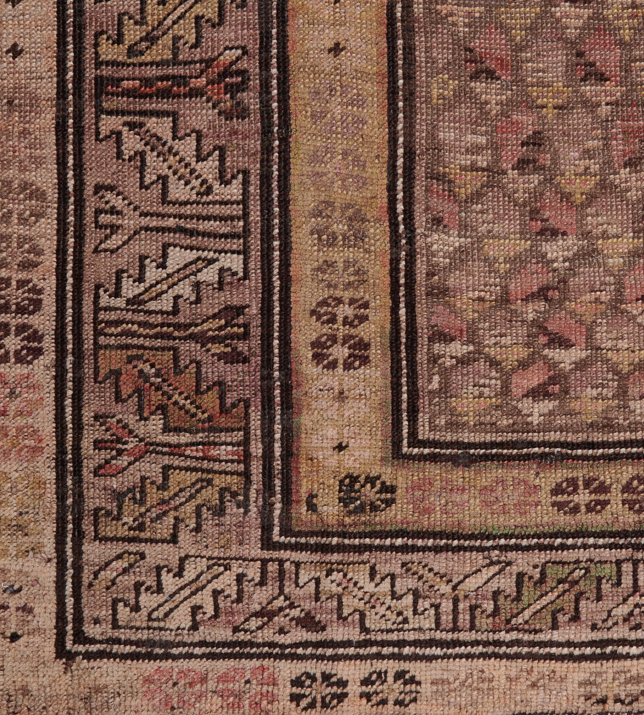 This traditional hand-woven Persian Karabagh rug has a shaded tobacco field with an overall copper paisley pattern, in a broad shaded tobacco serrated leaf border, between shaded sandy cream geometric rosette stripes.