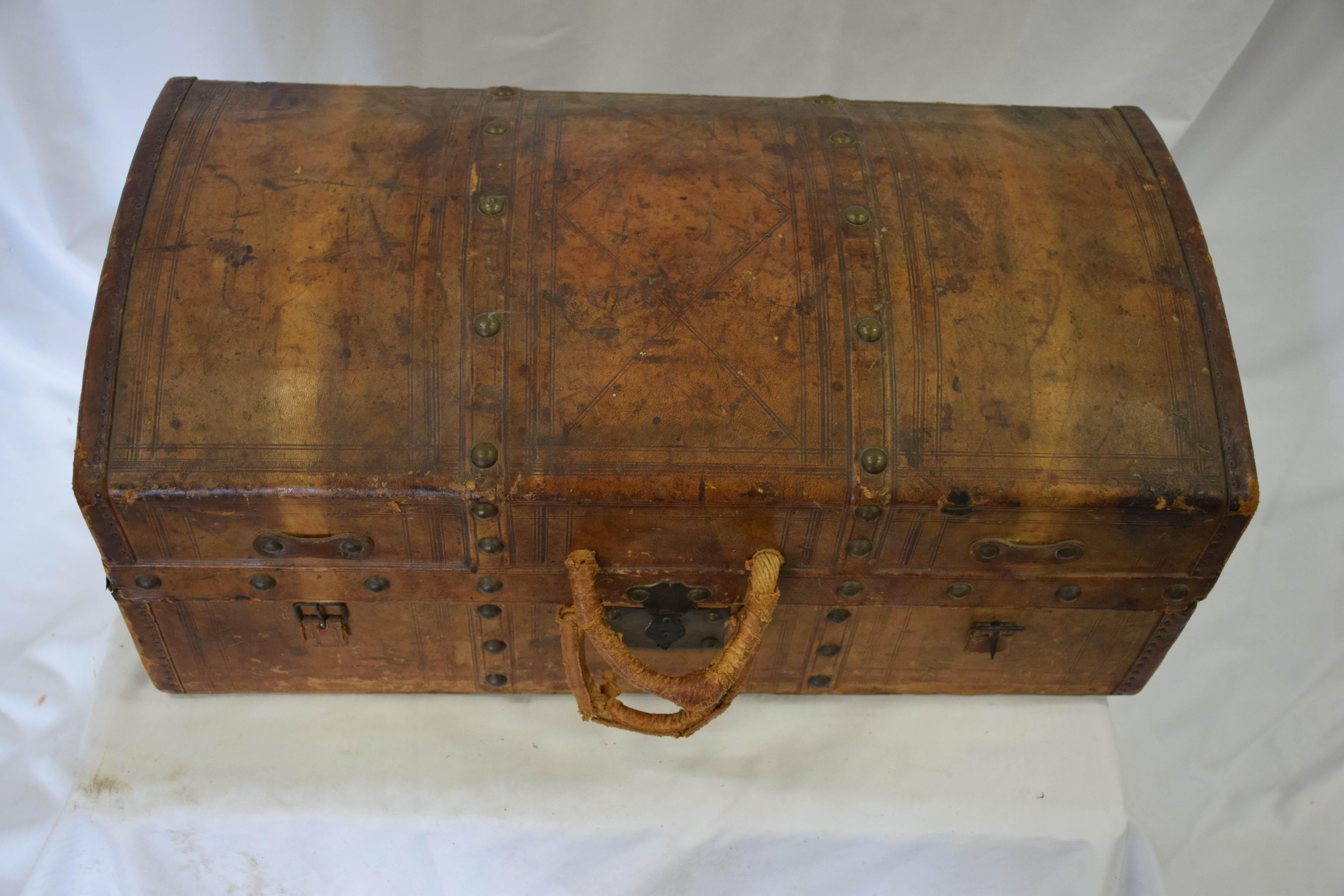 Antique travel dome trunk shipping luggage case in distressed vintage leather.
Fabulous toile fabric lined interior. With compartments. Charming historical character and vintage patina.
Original unrestored distressed condition. Scuffs present. No