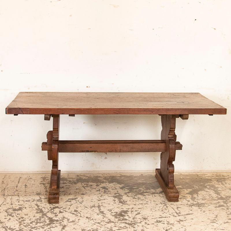 It is easy to imagine a family living in the European countryside eating breakfast at this strong oak table before beginning their day of work on the farm. There is something inviting about the simple, caved trestle base which creates the legs