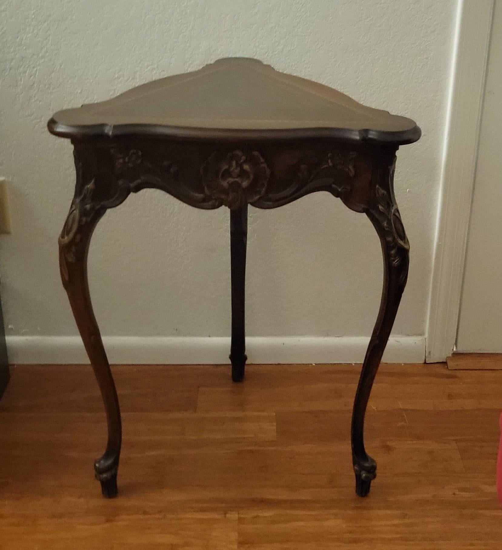 Antique style solid wood side table in a dark walnut finish and triangular shape. Made in 2011. This table has a polished top and three elegant hand-carved legs. The table is sturdy and in a very good condition. This table will make a great addition