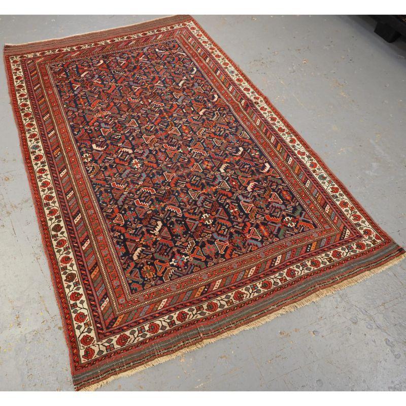 Antique tribal Afshar rug with repeat herati design.

An good tribal Afshar rug with a repeat herati (leaf) design on a dark indigo blue ground. The herati design is drawn in bands across the rug which is quite an unusual feature. Note the long
