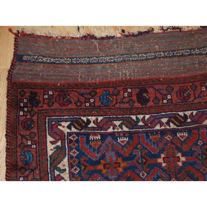 An interesting early tribal Afshar rug with a repeat herati (leaf) design on a dark indigo blue ground. The field is also covered with small tribal devices such as amulets. The borders are of classic design. Note the long kilim ends with a band of