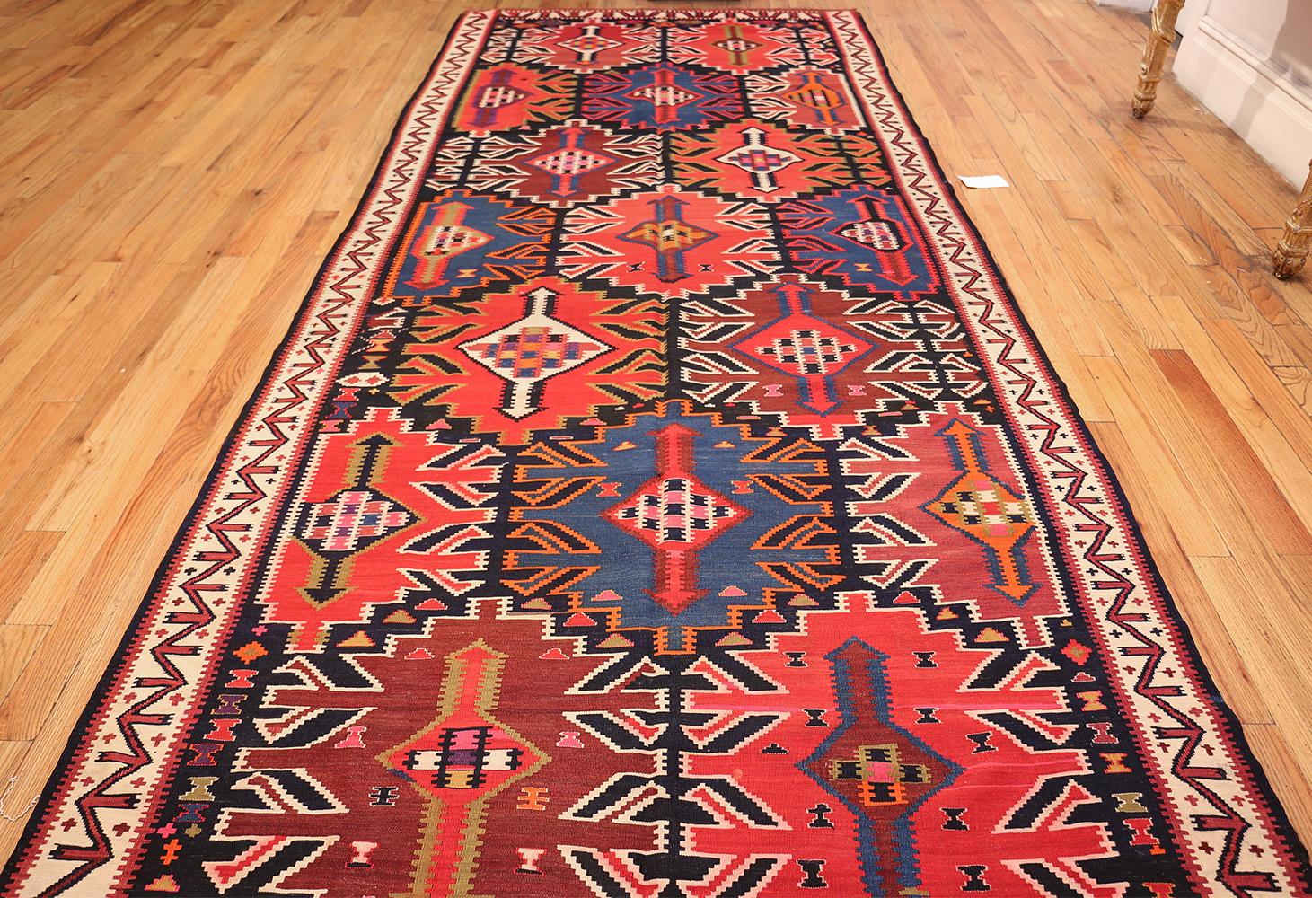 Antique tribal Caucasian Kuba Kilim rug, country of origin: Caucusus, date circa early 20th century. Size: 5 ft 7 in x 12 ft 9 in (1.7 m x 3.89 m)

True to the distinct tribal style of Caucasian Kuba Kilims, this rug combines extravagant colors with