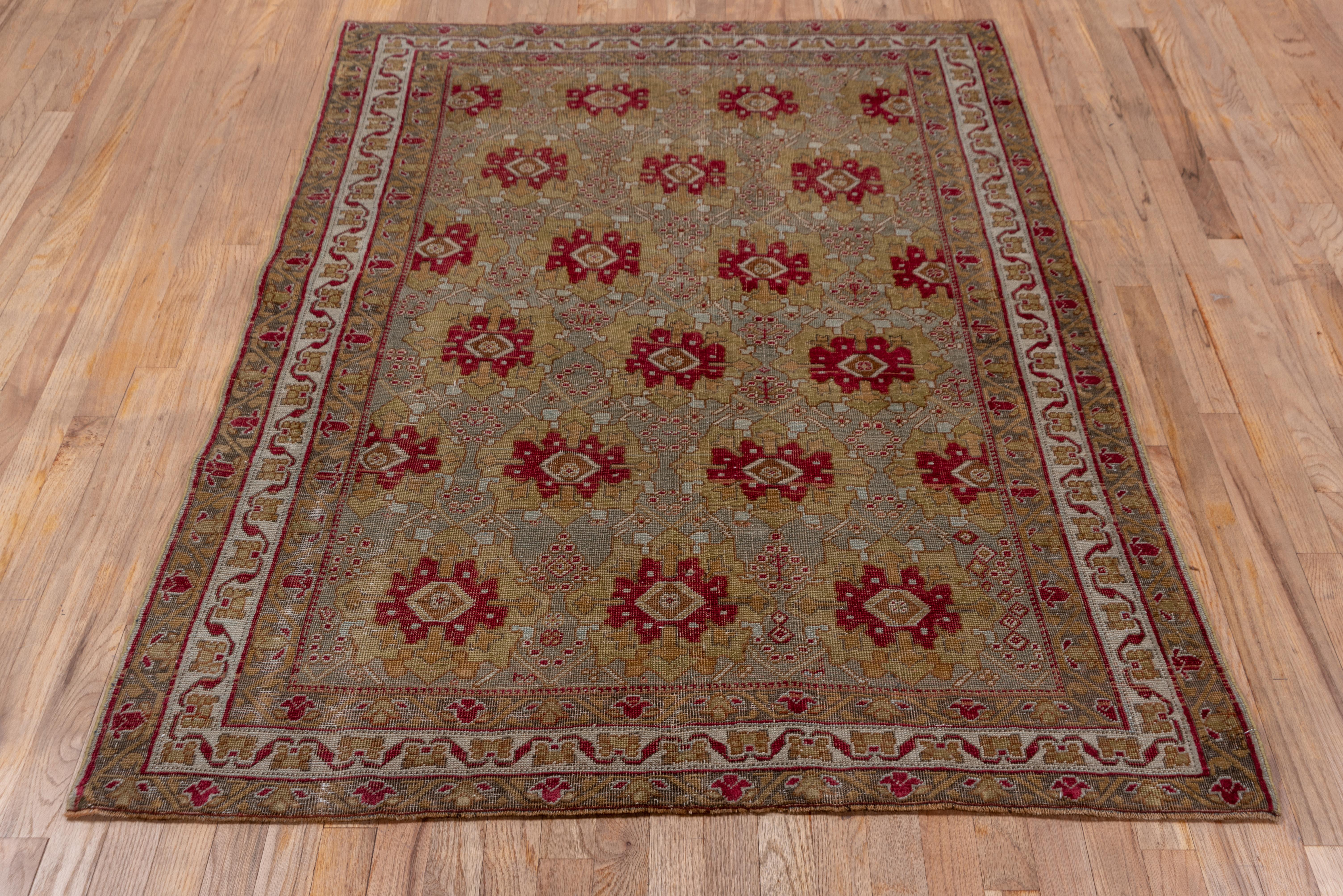 Six offset rows of complex rosettes with dark red centers decorate the mauvy-pink field of this SE Persian nomadic scatter with an ecru main border of squared fan palmettes. Characteristic pattern and weave quality.