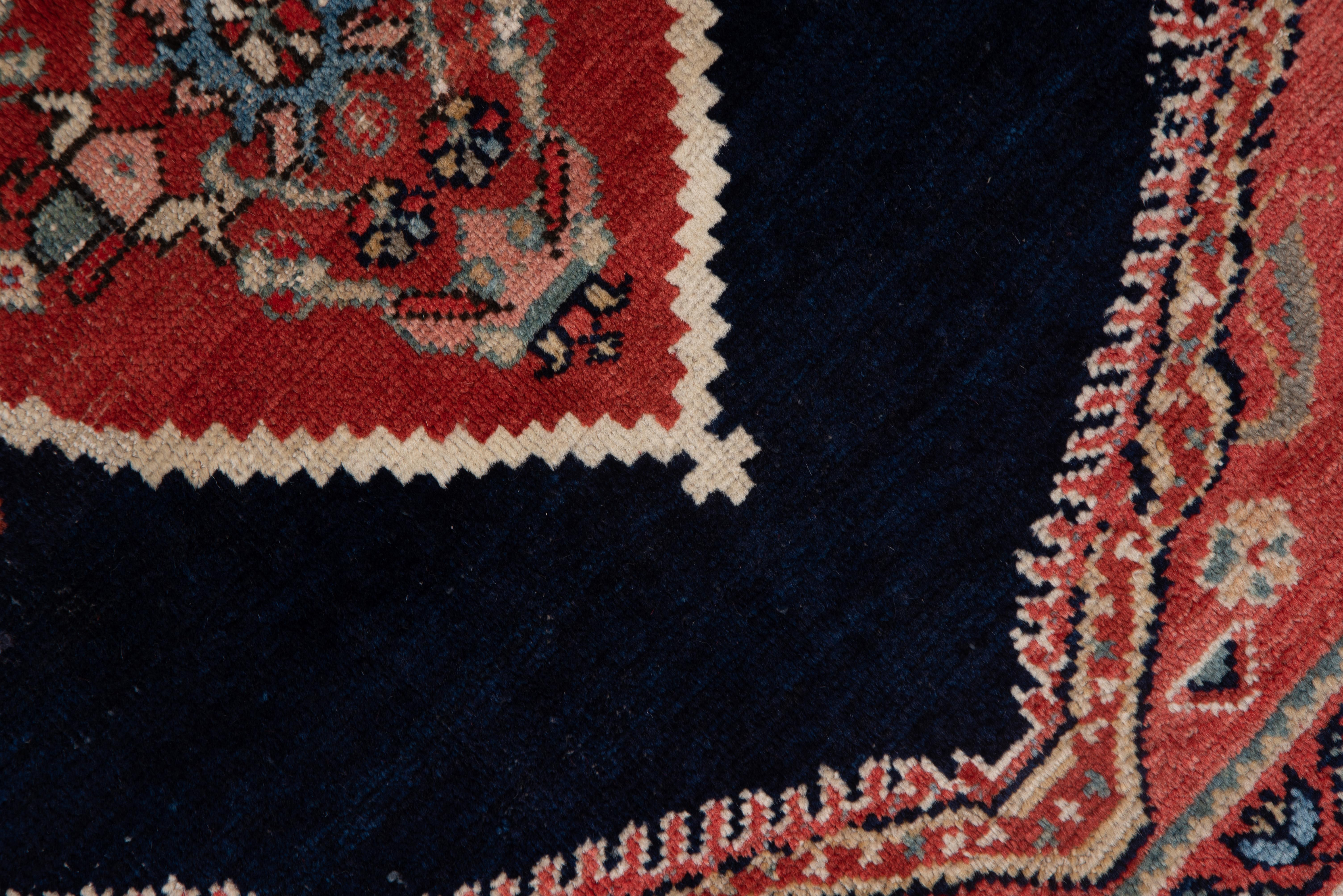 The rich navy field is centered by a triple diamond pole medallion on this very well colored west Persian rustic scatter in very good condition. Along the zig-zag sides of the field are sand and pale teal triangles, and the light red joined corners