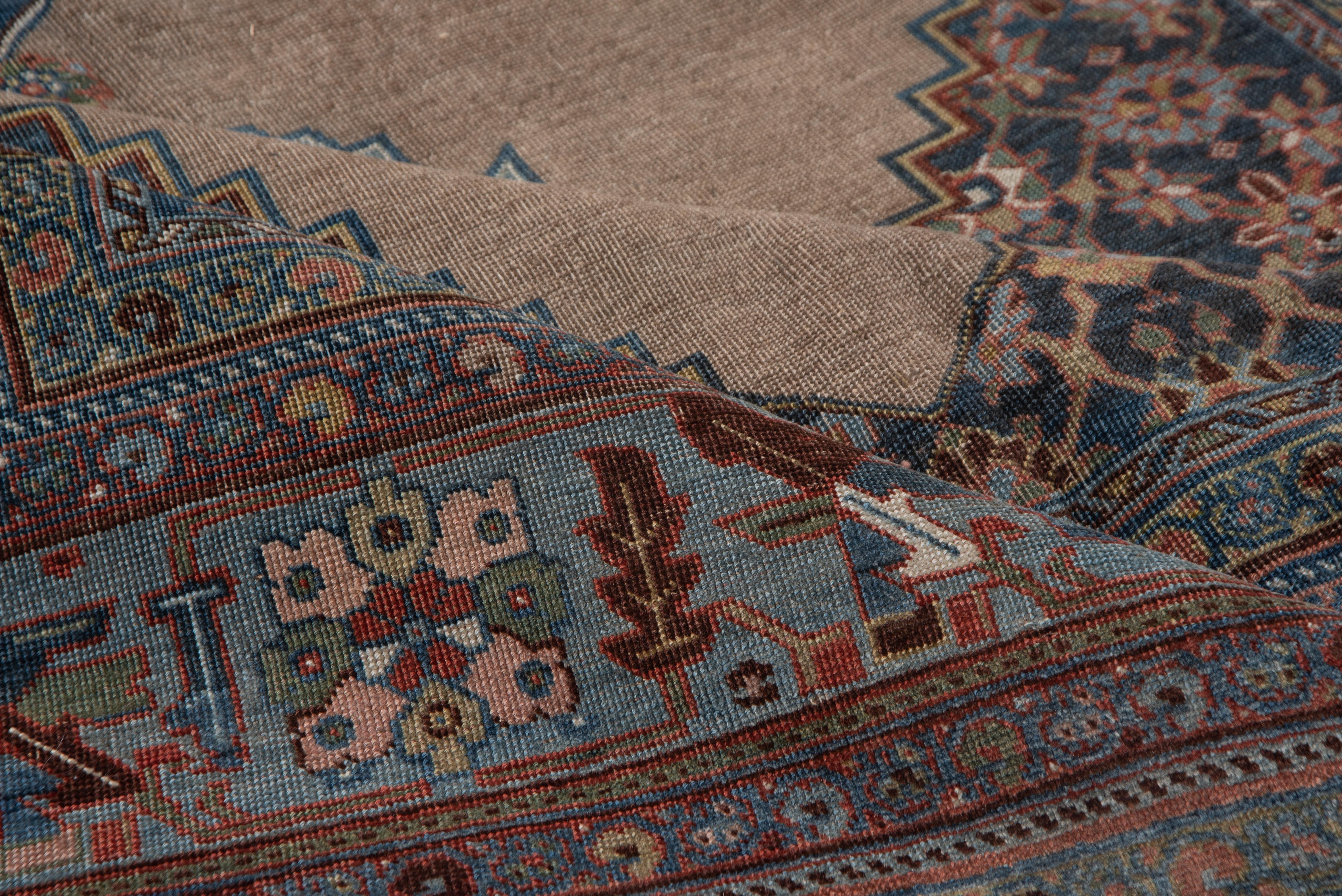 This utterly Classic Kurdish town carpet shows an open, stepped light rust field within abrashed dark blue conjoint Mina Khani design corners and with a matching stepped diamond medallion with pale blue pendants. Beautiful light blue 