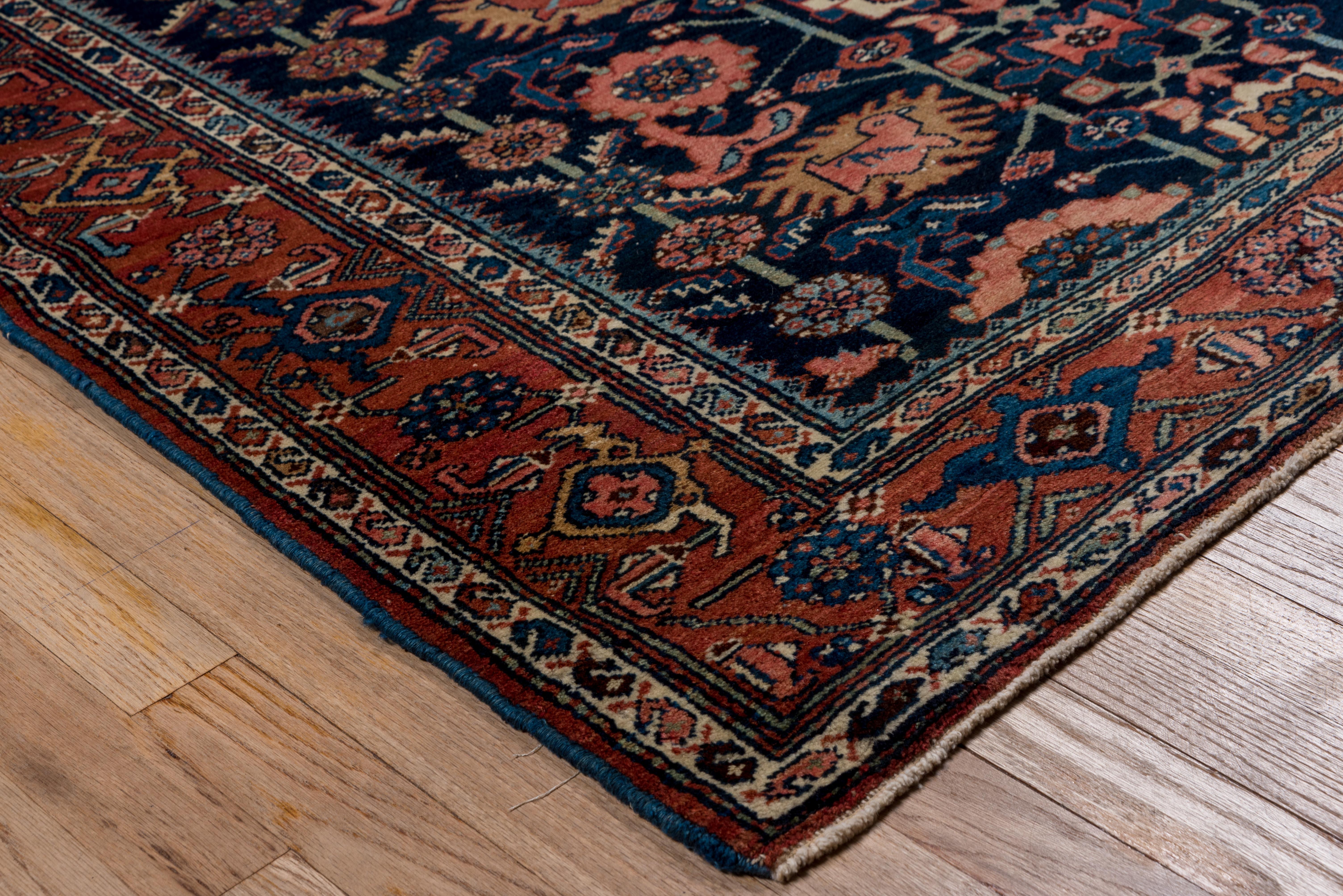The navy field of this particularly compactly woven west Persian village scatter has a variant of the traditional Avshan design with rotund birds in several of the fringed motives, along with the usual rosettes and 
