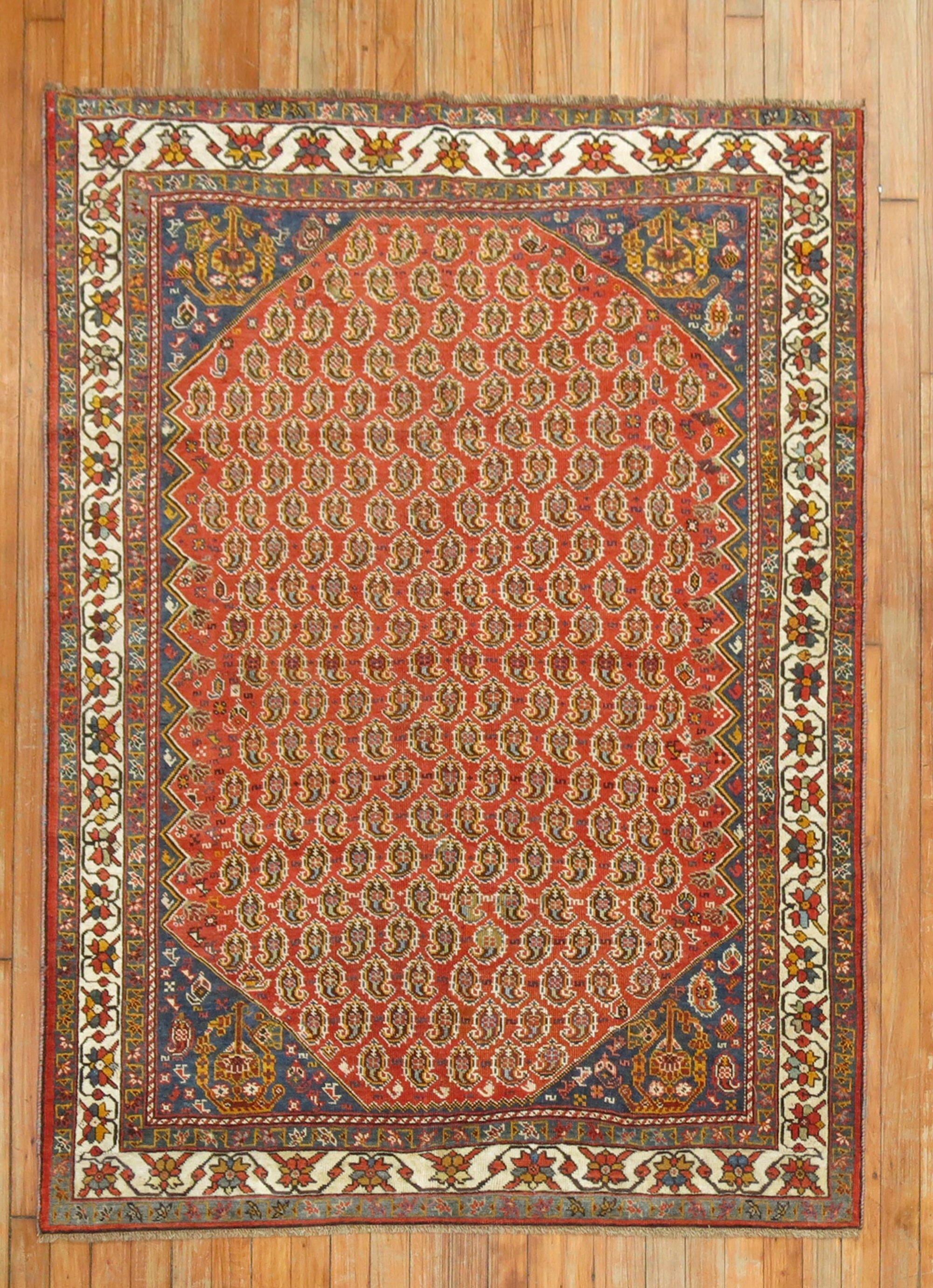 An authentic Persian Ghashghai rug featuring a boteh design on red ground,

circa 1910. Measures: 4' x 5'1