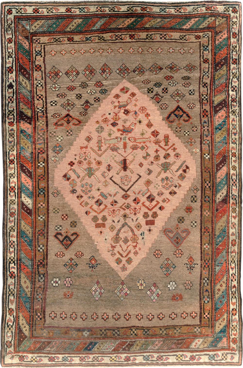 An early 20th-century Persian Kurd Tribal accent size rug.

Measures: 5' x 7'7'.