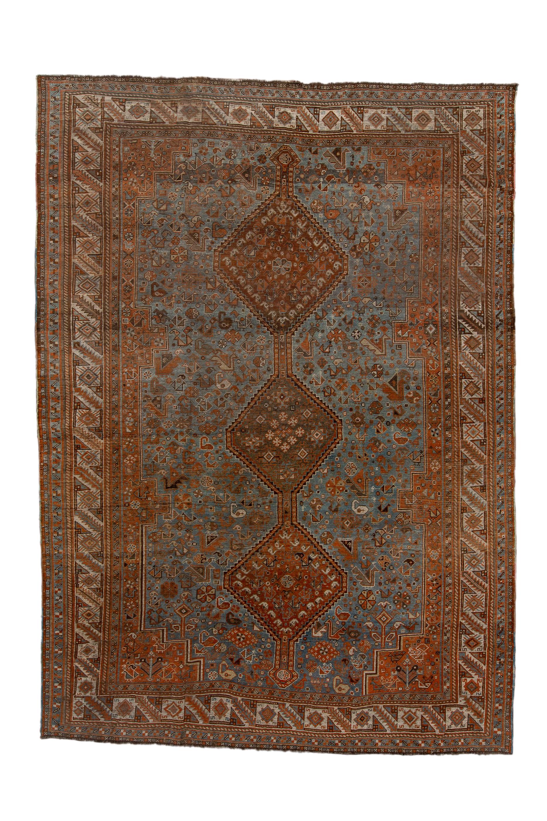 Shiraz/Khamseh Carpet
Southwest Persia, Fars Province

This large tribal piece shows a tripartite pole medallion, with hooked edge, and displaying tiny botehs and floral devices, against a light blue subfield decorated with characteristic chickens,