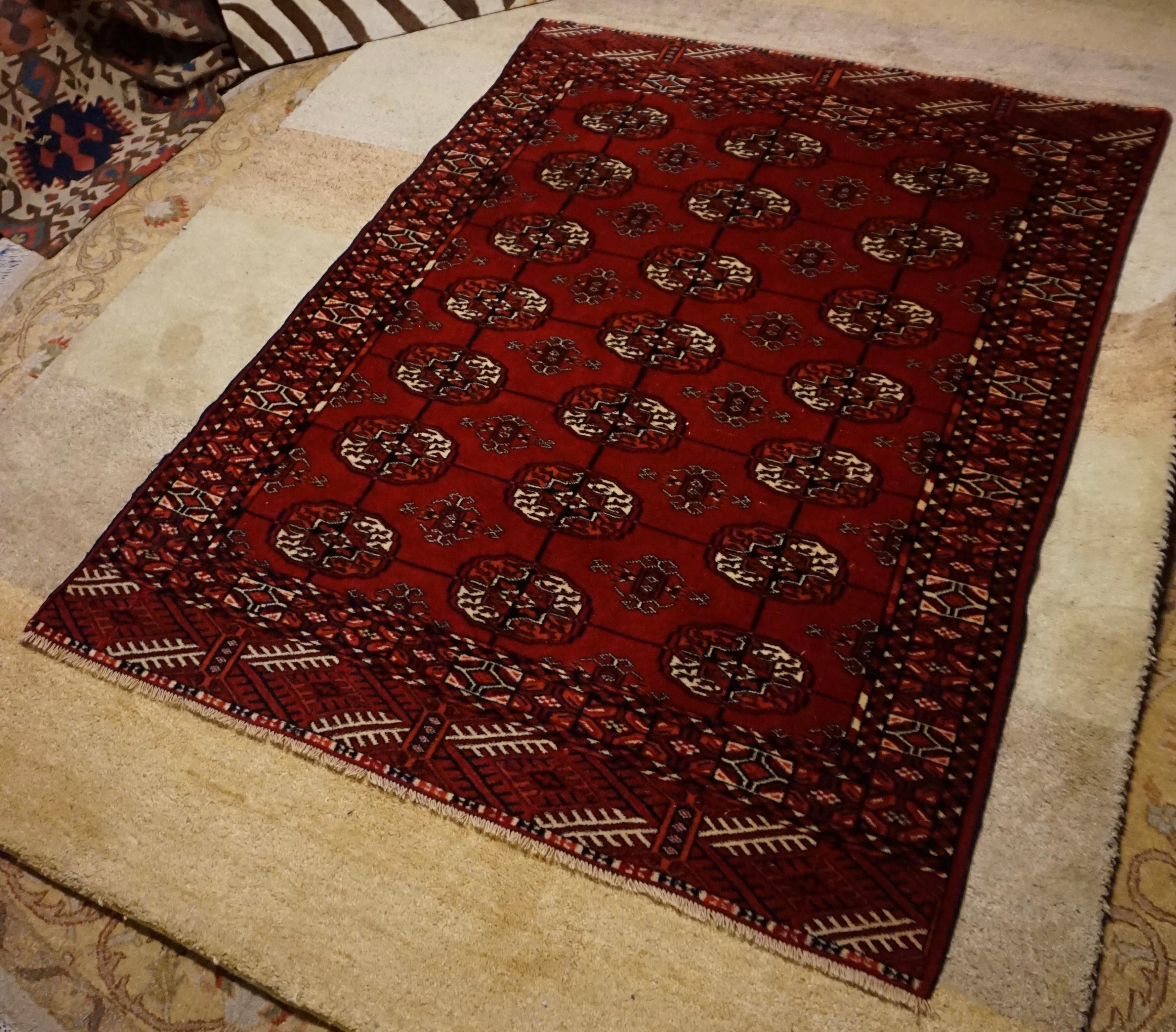Traditional Turkomen Bokhara carpet in deep reds with elephant's foot pattern. Finely knotted and in good overall condition despite minor pile wear,

circa 1930s.