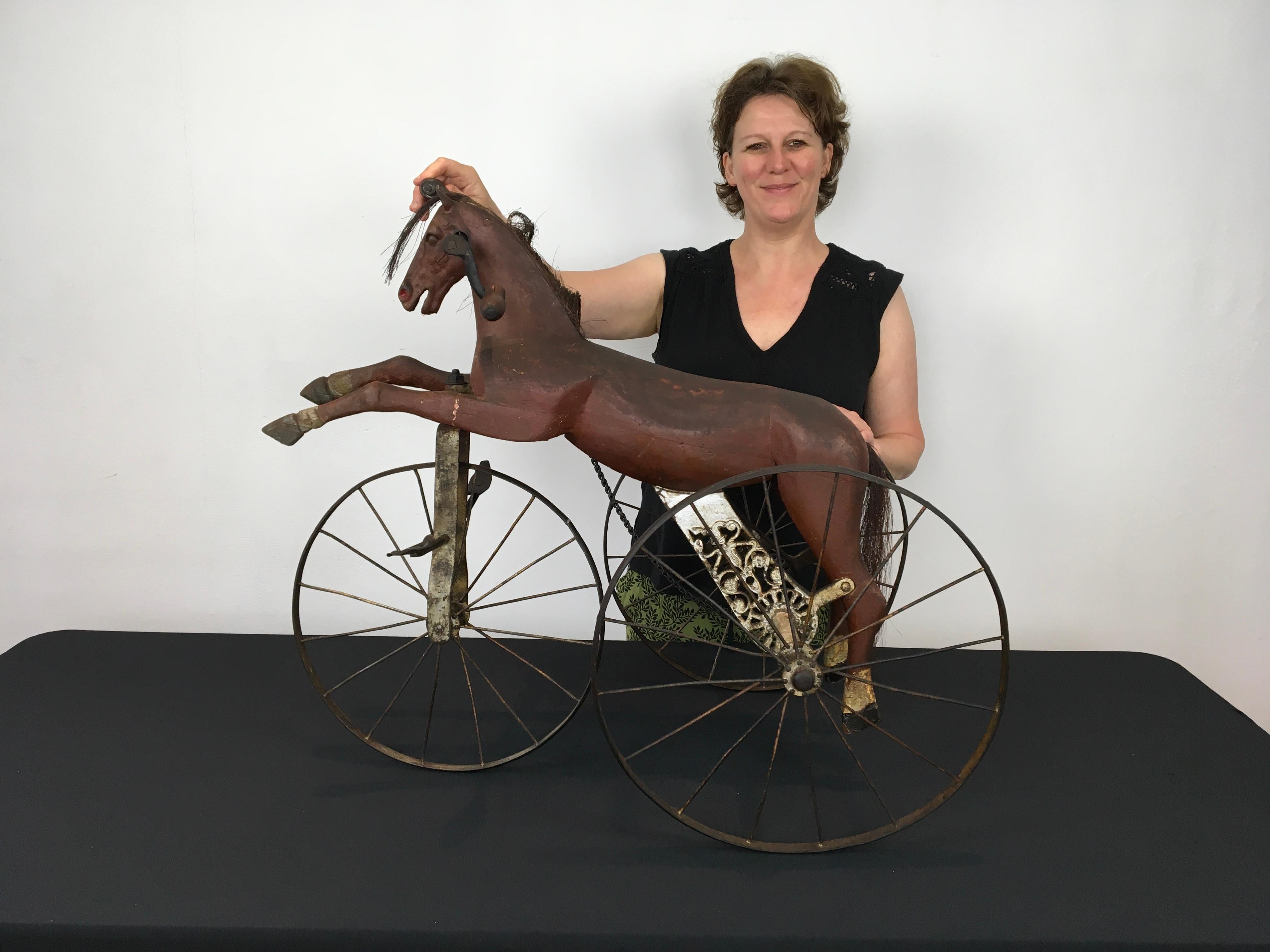 Antique tricycle horse toy - children's tricycle with horse. 
A French antique horse toy circa 1890 - 1910.
A horse toy on three iron wheels - tricycle toy.
The horse head is made of iron,  the body of the horse is carved wood with also wooden