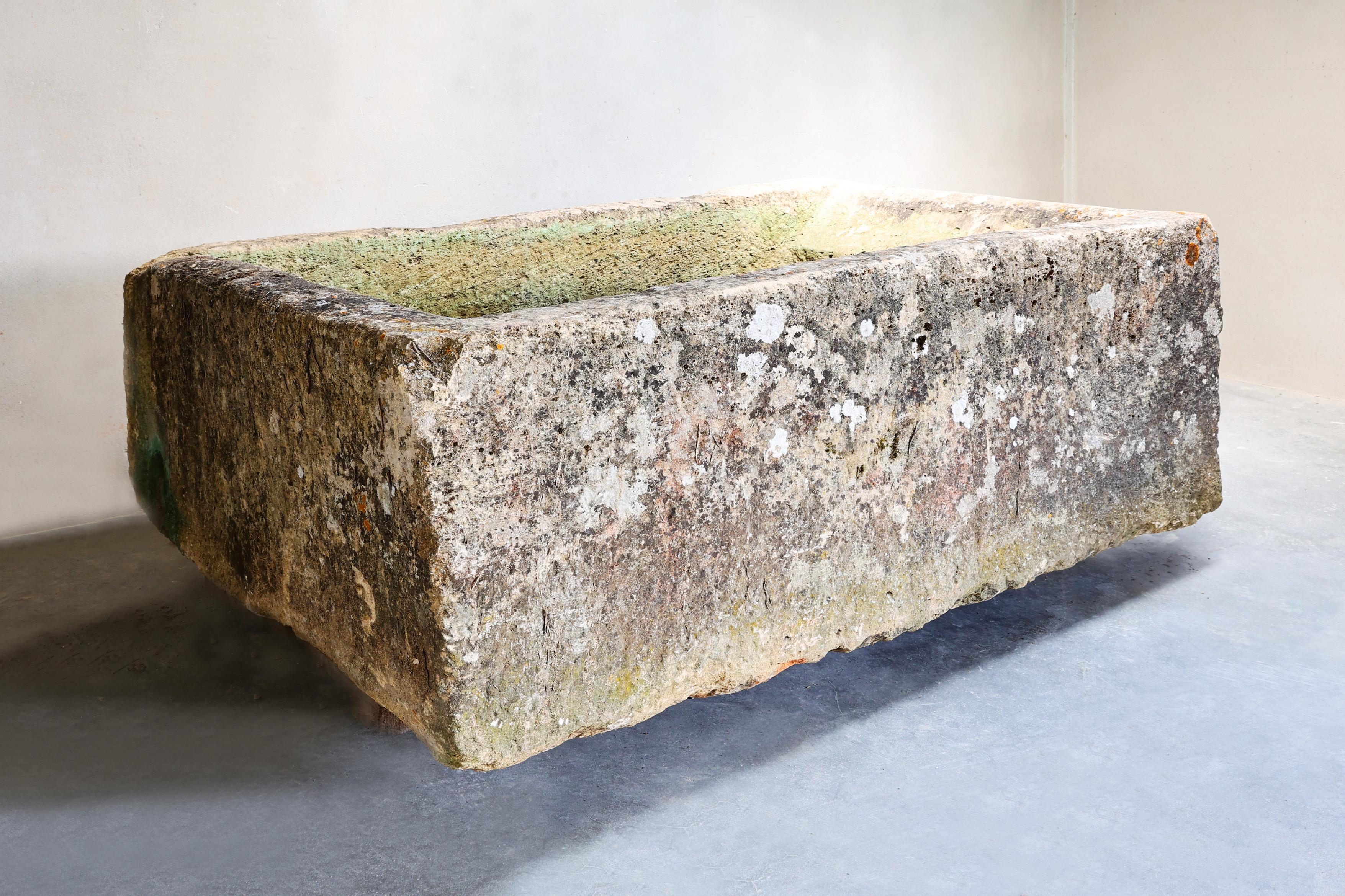 19th Century French Hand-Carved Limestone Trough

A striking and authentic 19th-century French limestone trough, hand-carved from a single block of stone. This rustic piece bears the beautiful patina of age, with natural weathering, moss traces, and