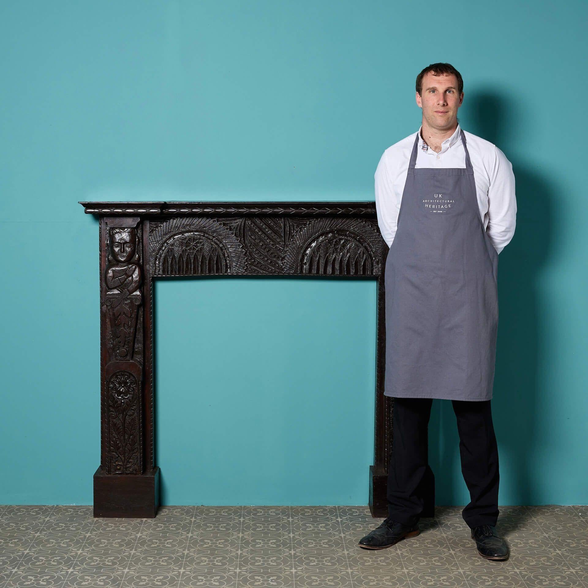An antique Tudor style carved oak fireplace.

Hand crafted with ornate carvings of stylised floral designs throughout and caryatid figures to the end blocks, this stylish antique fire surround is a handsome addition to interiors traditional and