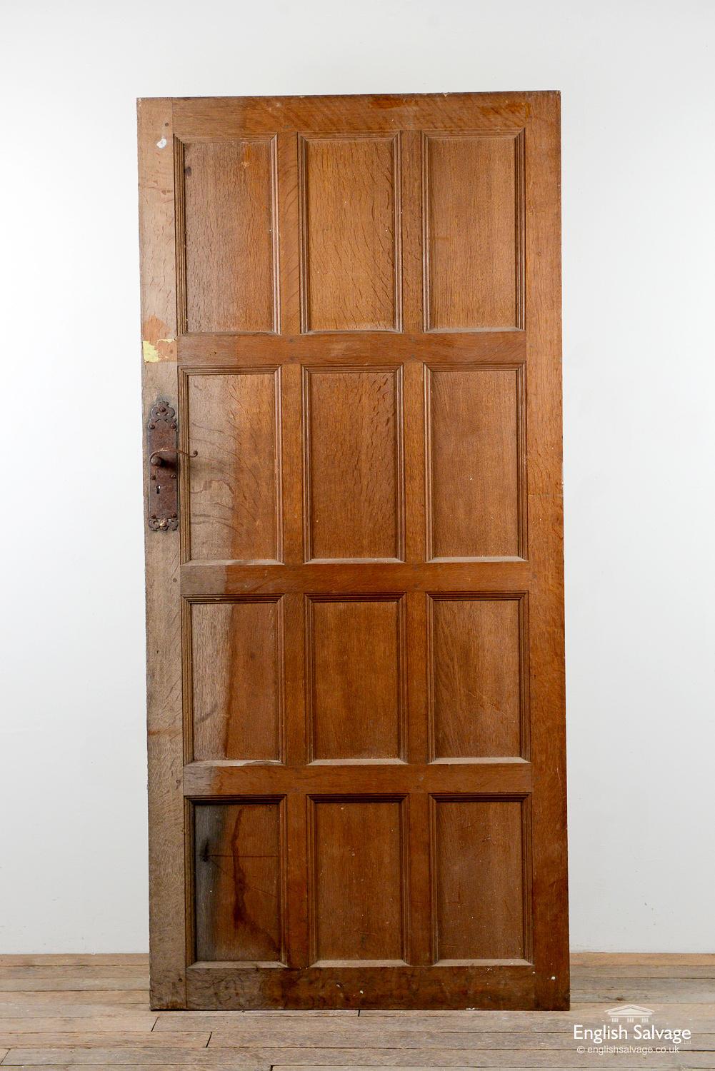 Reclaimed antique oak door, 1900s, with Tudor style panelling, ornate hinges and door plates. Bumps to edges and corners as expected with age.
