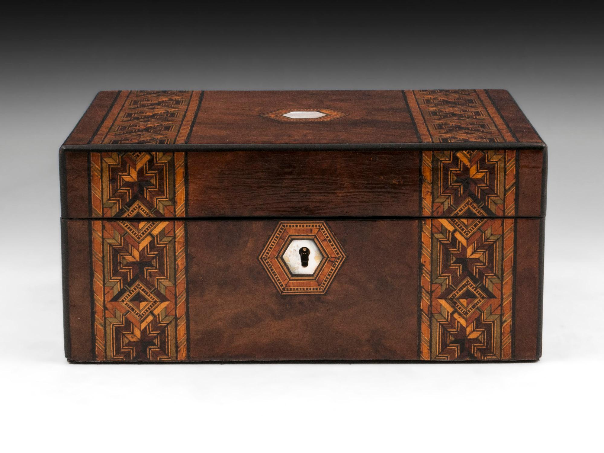 Antique jewelry box veneered in figured burr walnut with ebony edging and two decorative inlaid bands running from the front to the top of the box. With mother-of-pearl initial plate and escutcheon. 

The interior of this antique jewelry box