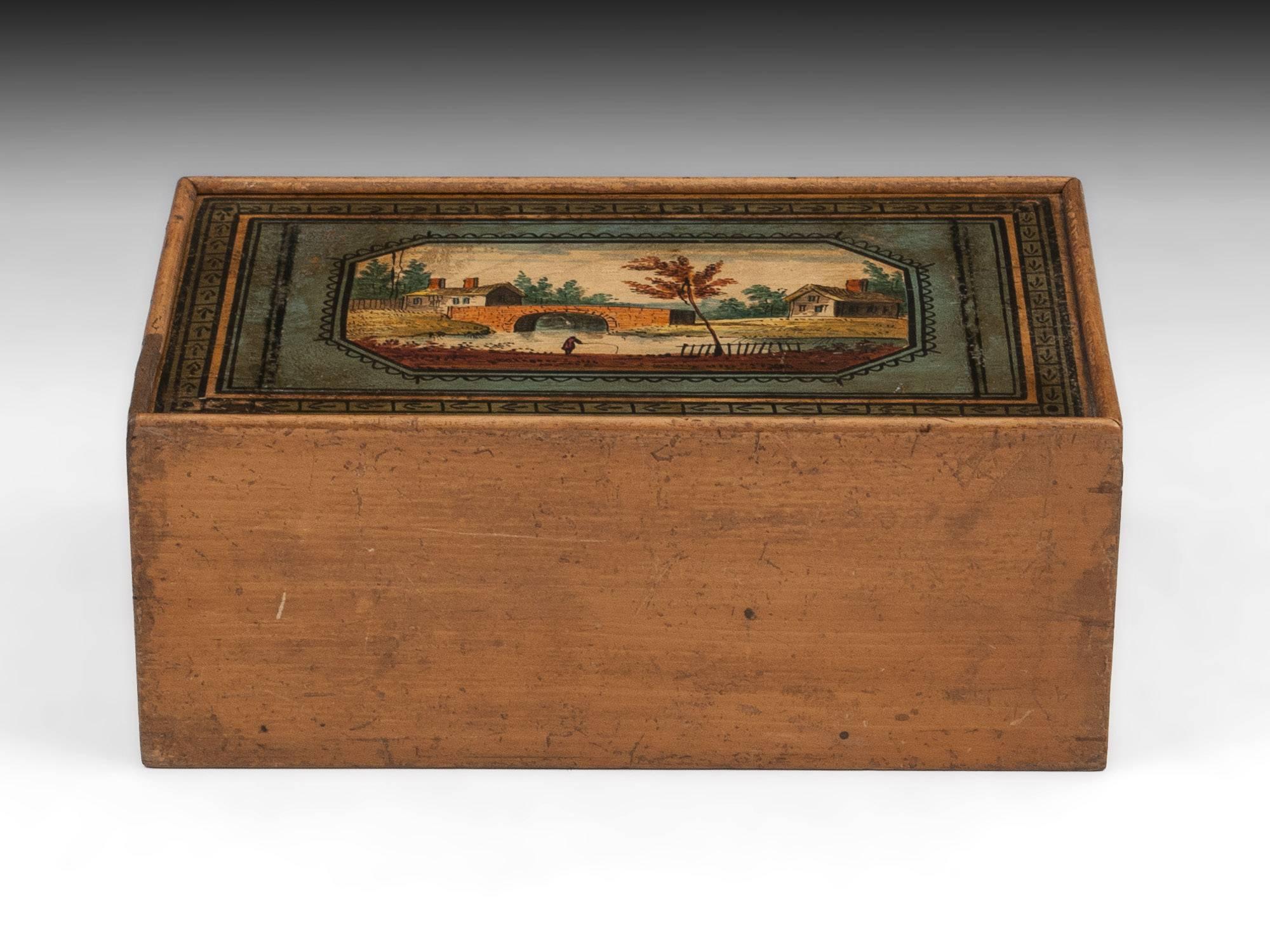 Early painted Tunbridge Ware sewing box with a lockable sliding lid, decorated with a rural scene with a figure fishing. 

The interior is lined with pink paper. The tunbridge sewing box comes with a fully working lock and tasselled key.
 