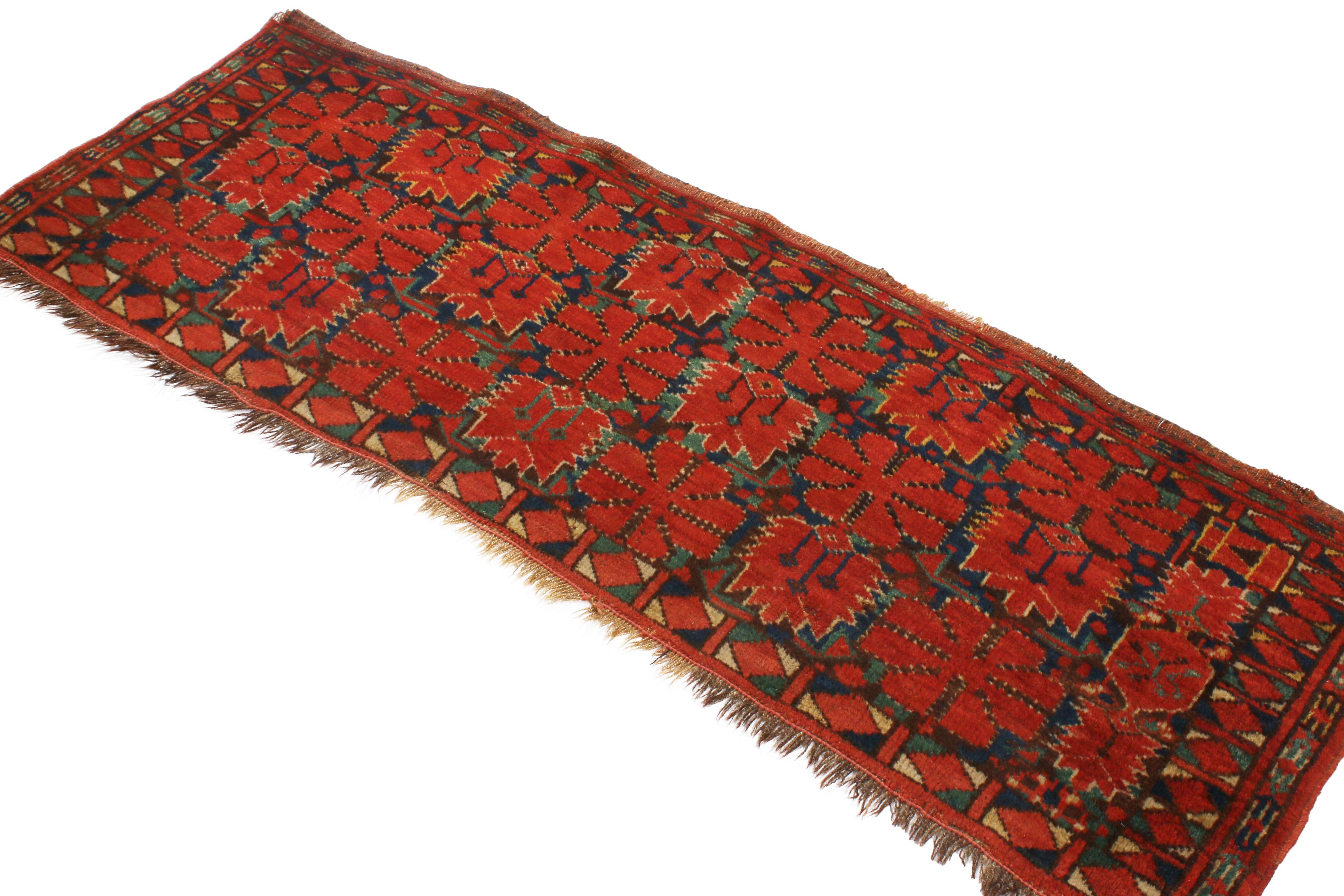 Originating from Russia in 1890, this antique, hand knotted wool Turkeman rug enjoys a distinct combination of gentle and stylistically tribal red floral motifs set against a luminous green background, permeating the field as well as the