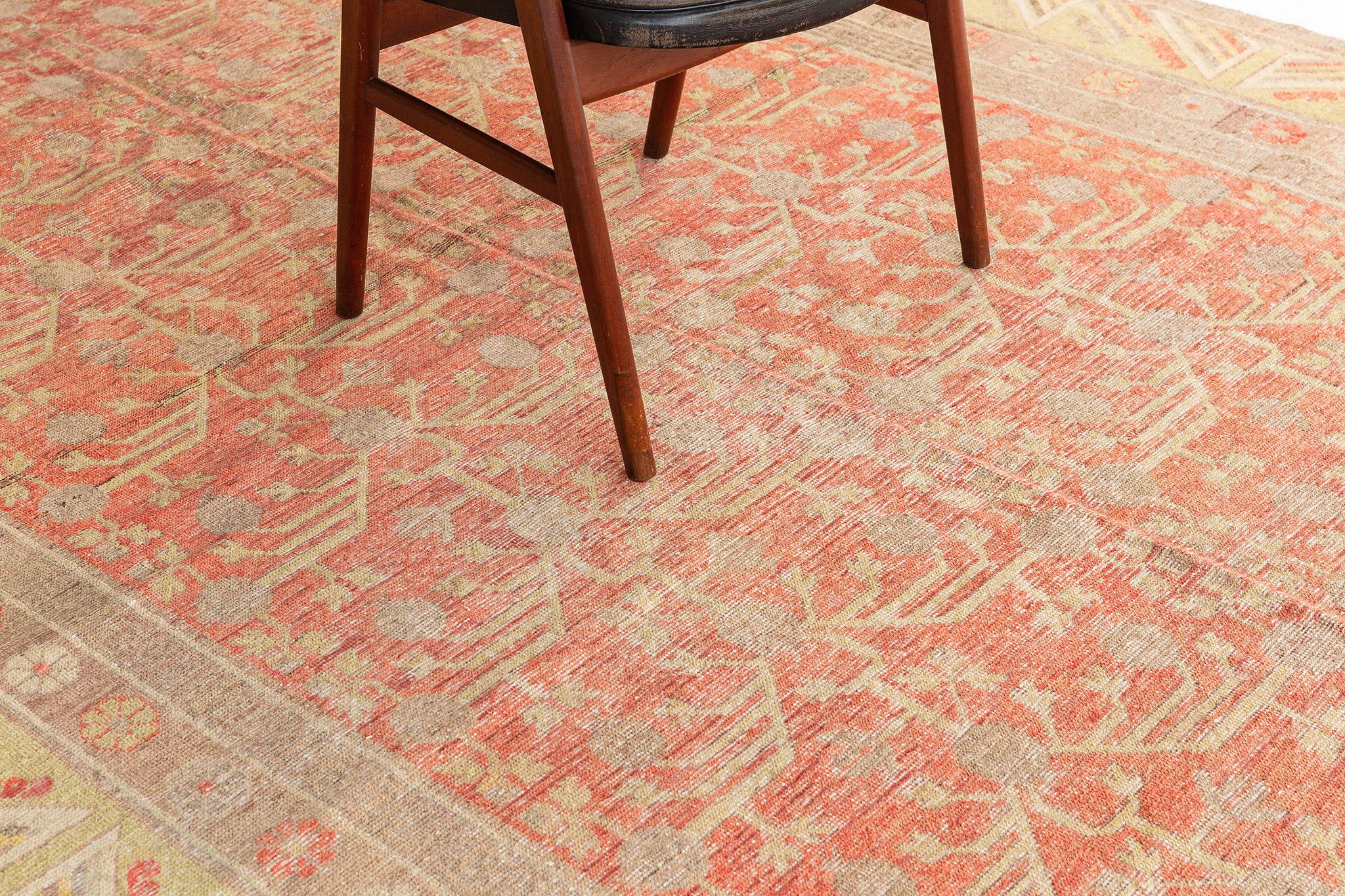 With its striking appeal and architectural elements of naturalistic forms, thisantique Turkestan Khotan rug can beautifully blend modern, traditional, and contemporary interiors. The weathered field is covered in an all-over botanical pomegranate