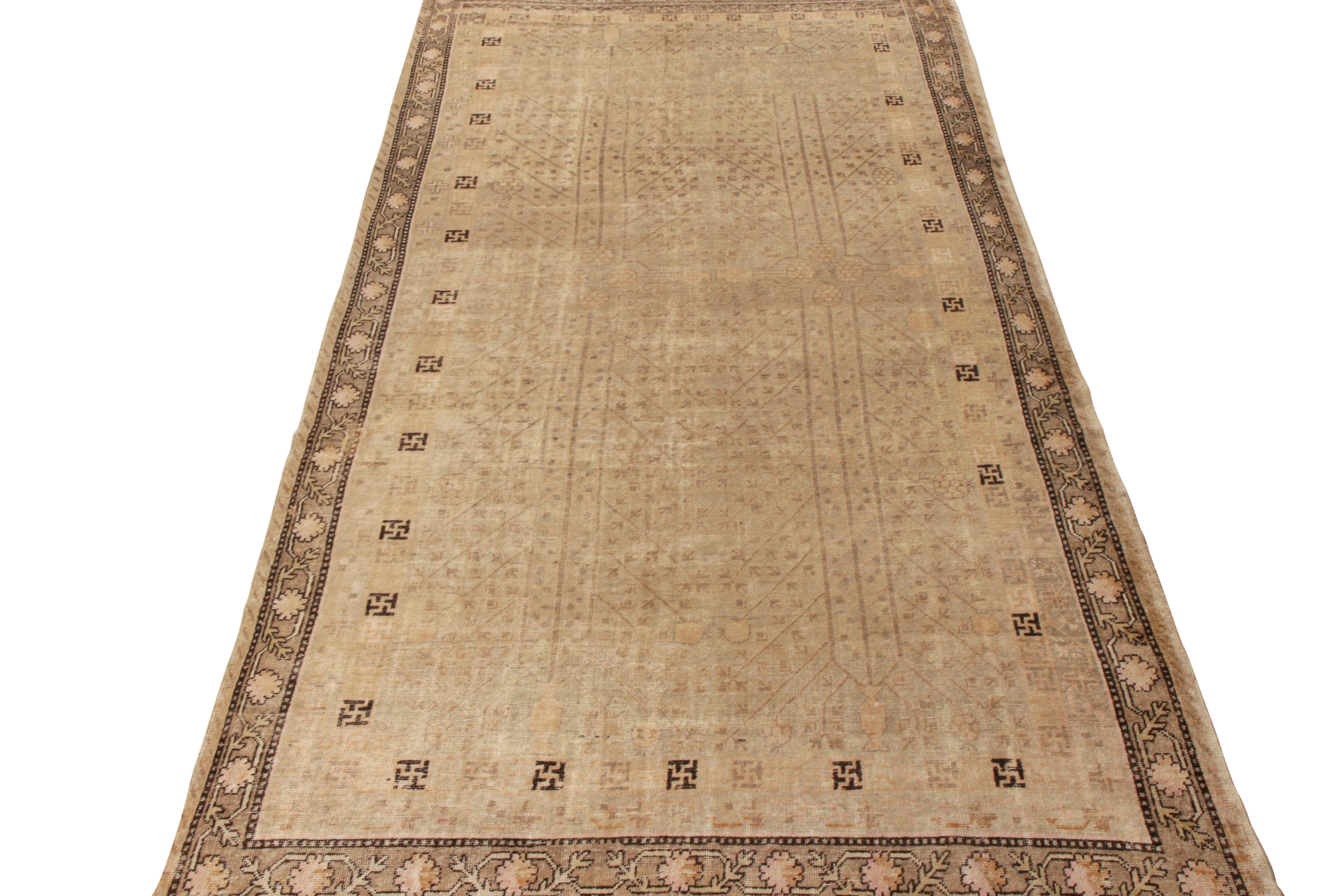 Noué à la main en laine de qualité, ce tapis Khotan ancien de 6x12 est originaire du Turkestan vers 1920-1930. Ce dessin sourd se décline dans de délicieux tons de beige-brun et de doré qui complètent à merveille le motif géométrique. Alors que le