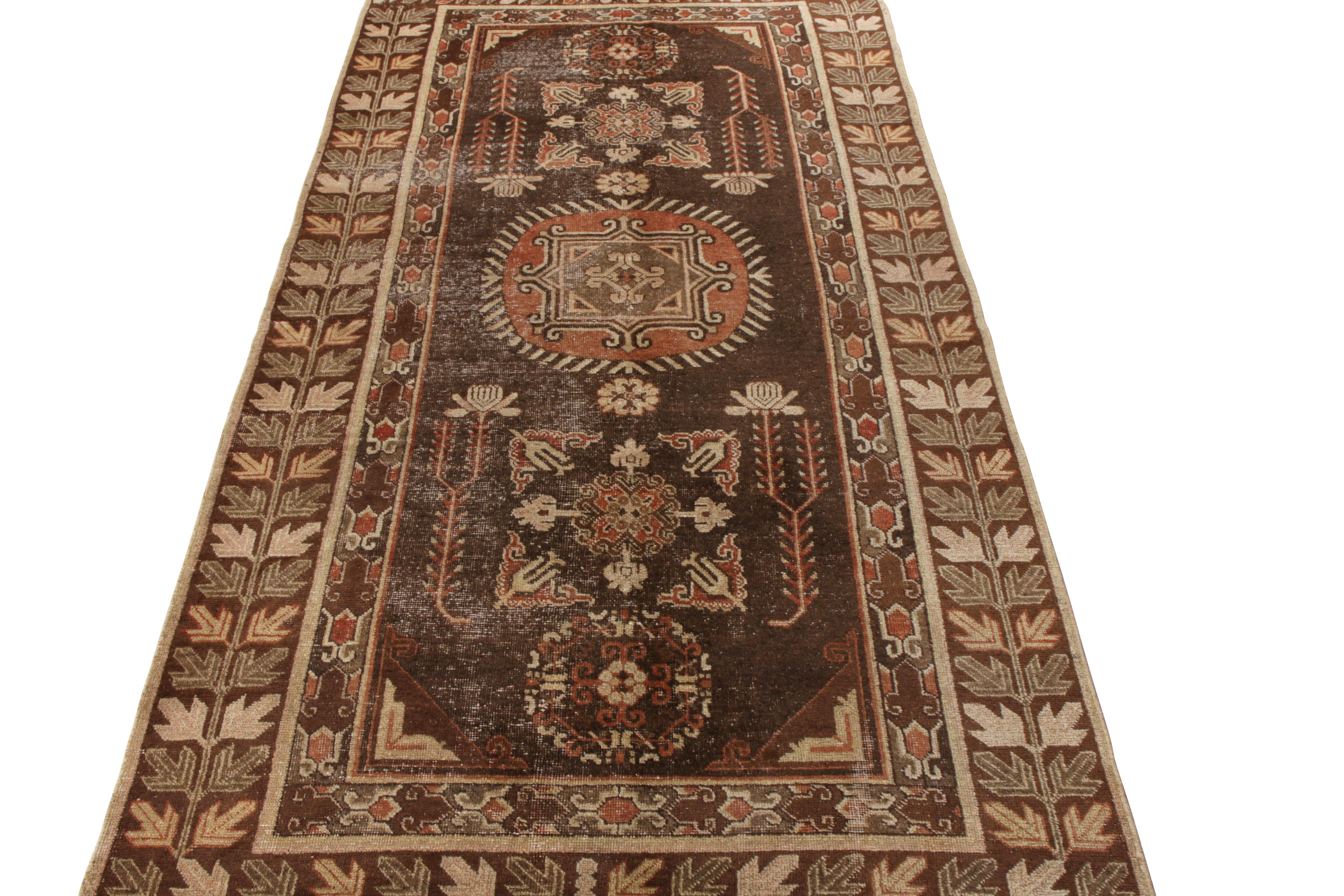 Hand knotted in rare quality wool, this 5x10 antique Khotan runner originates from East Turkestan circa 1920-1930. This rustic drawing enjoys a blissful union of patterns in an abrashed colorway of rust red, beige, brown with light green and orange