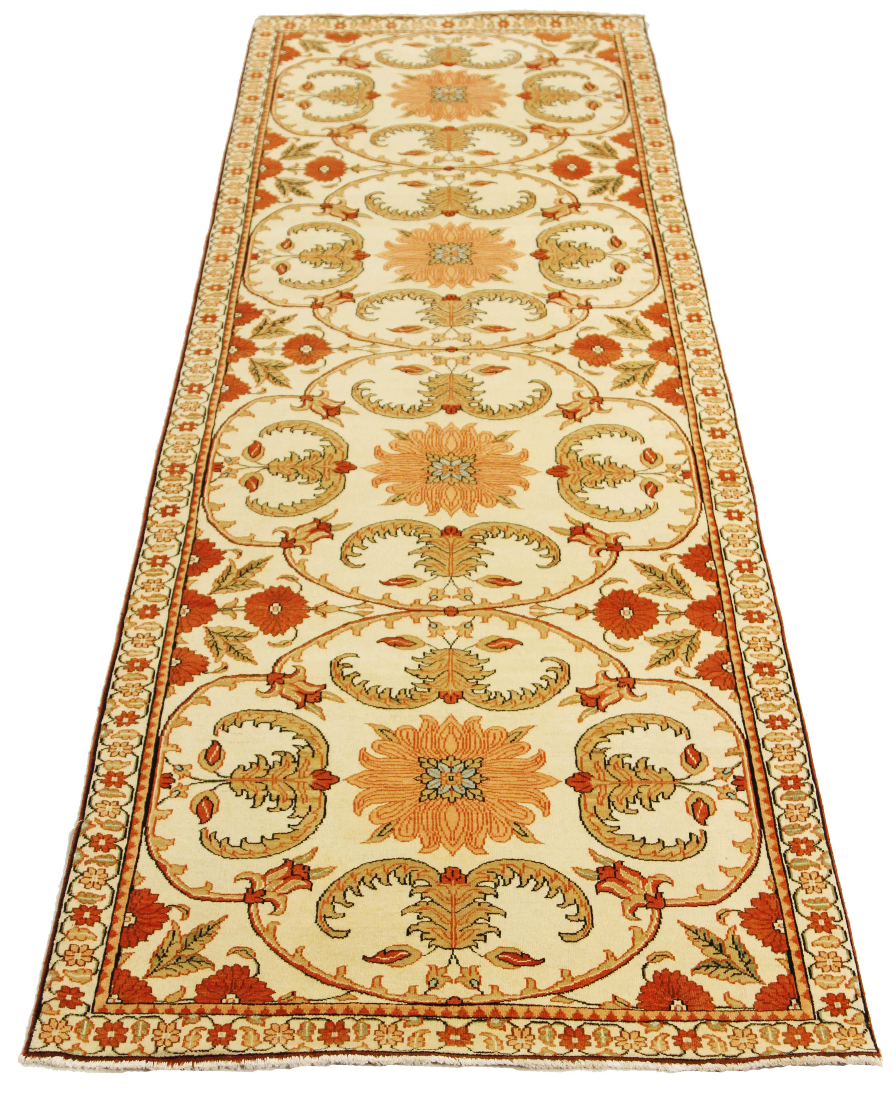 Antique Turkish rug handwoven from the finest sheep’s wool and colored with all-natural vegetable dyes that are safe for humans and pets. It’s a traditional Agra weaving design featuring botanical patterns in orange and beige on a plush ivory field.