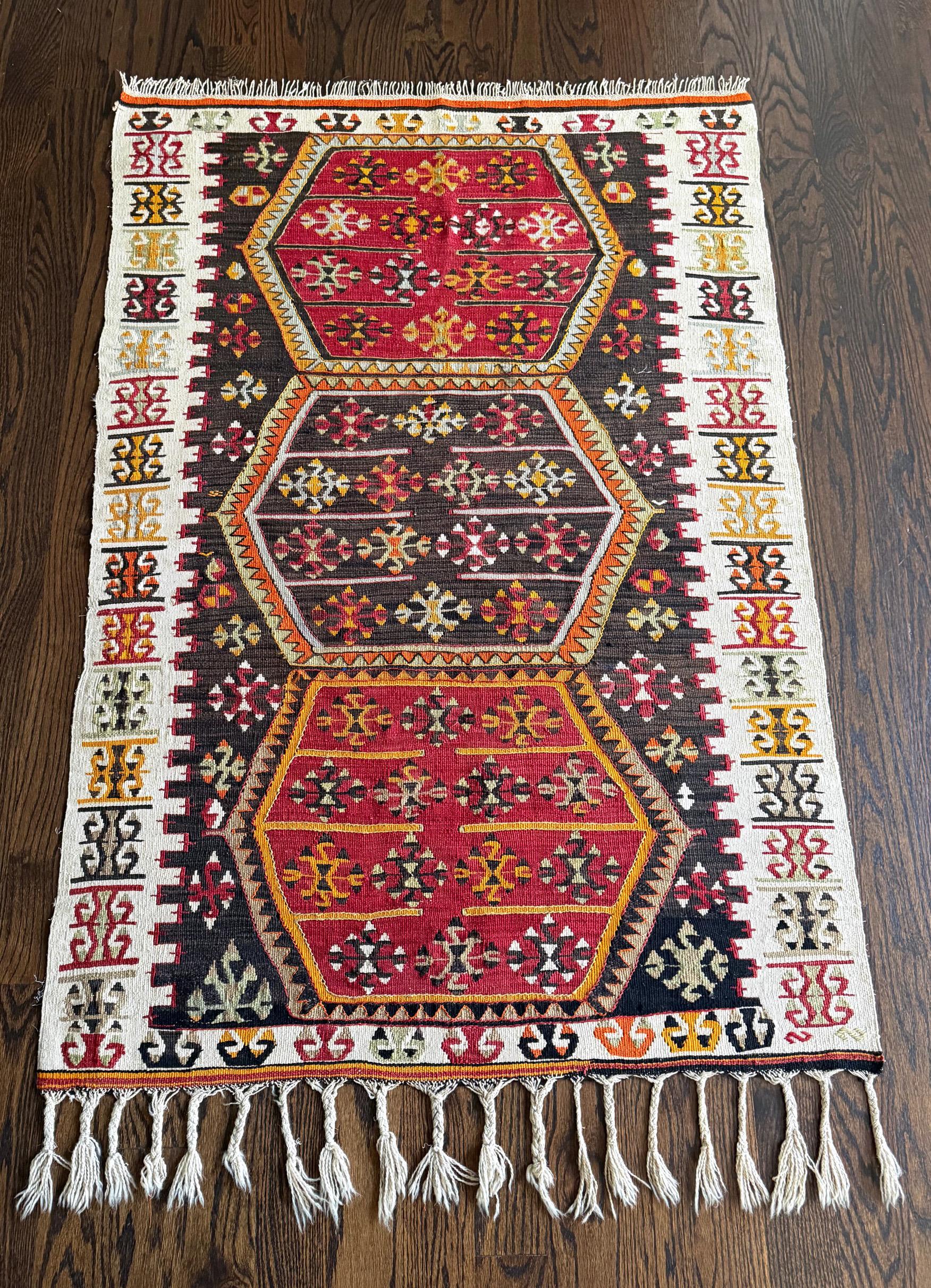An antique Eastern Turkish wool kilim rug from Anatolia region circa 19th century. The finely woven rug is professionally mounted on a linen-backed canvas for display. The tribal weaving features three stacked hexagons in the center field with