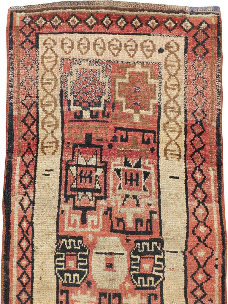 An antique Turkish Anatolian runner from the early 20th century. Anatolian, the rose-red field displays a geometric pattern of Memling guls (flowers), stars, cartouches-in-boxes and other hard to describe motives because of the rugs tribal nature. A