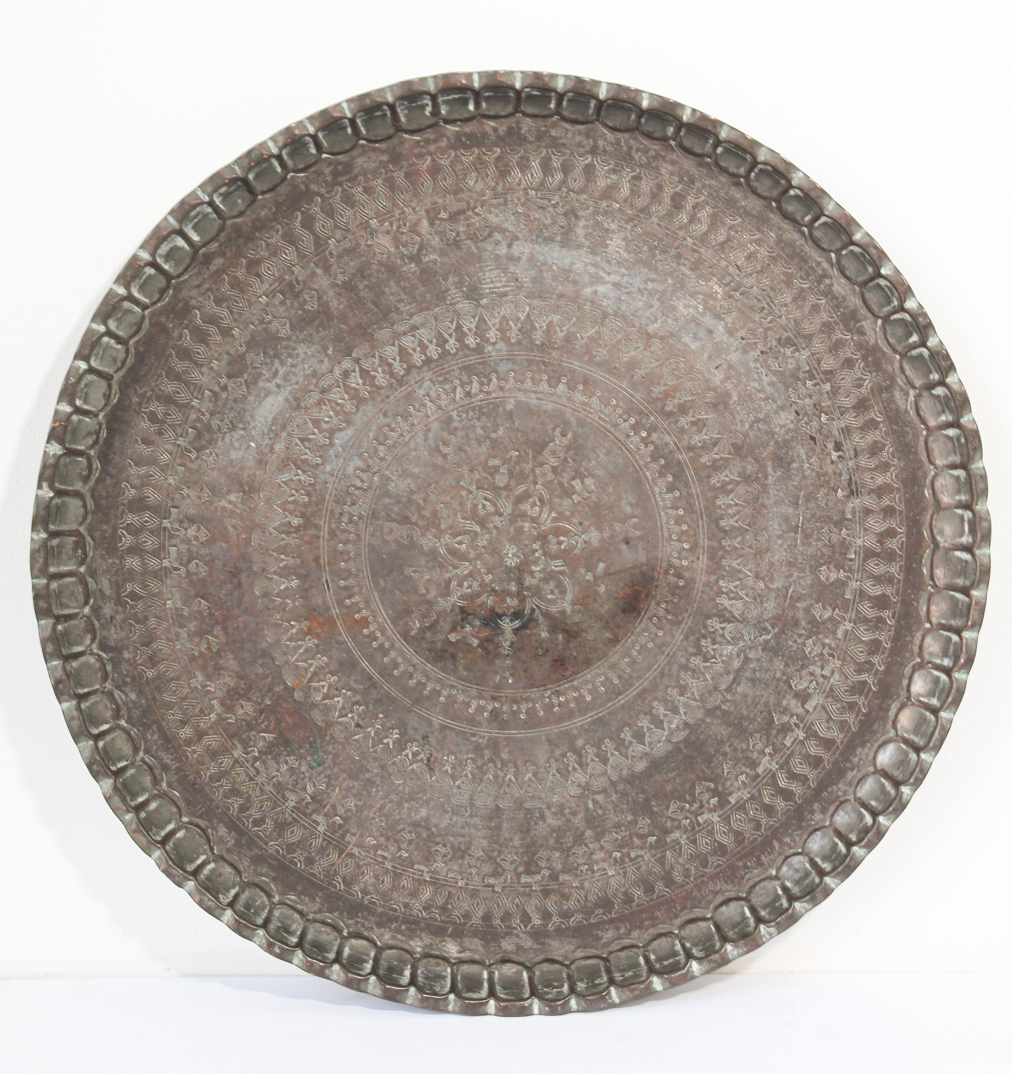 A large-scale 19th century Moorish style charger. 
With deeply scalloped hand-hammered edge, with intricate incised geometric decoration, floral arabesques spiraling from the centre,
Antique Turkish Persian Mameluke style tinned copper circular