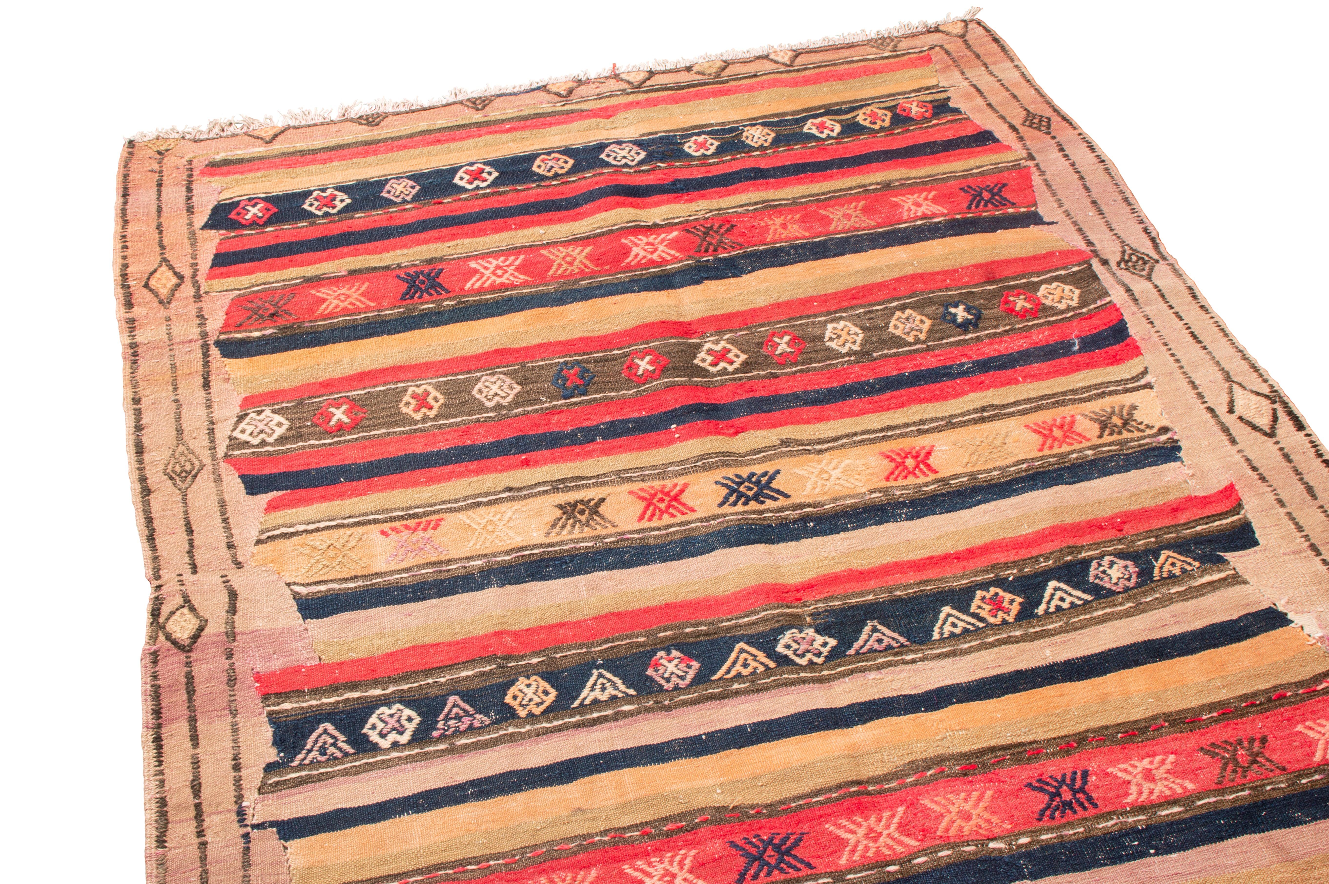 Originating from Turkey in 1920, this antique authentic Turkish wool kilim rug from Rug & Kilim features a wrapping border of symbolic diamonds and a field design employing rows of stars and protective medallions. Flat woven in durable, tight wool,