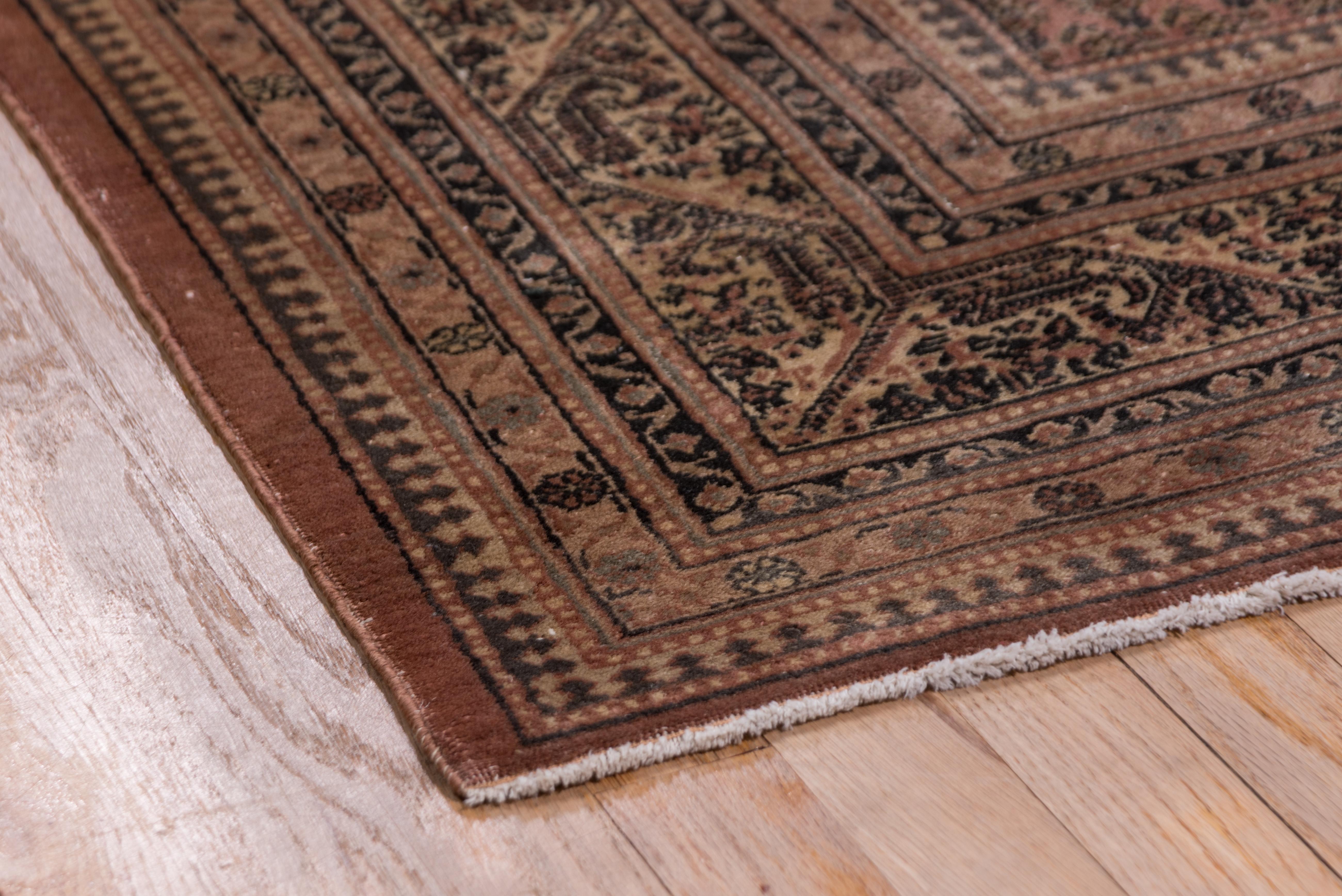 This distressed eastern Anatolian town carpet has a small Saraband boteh-miri all-over pattern on an abrashed dusty pink to pale terracotta ground. Ivory Saraband-style border of botehs hanging from an angular Meander.