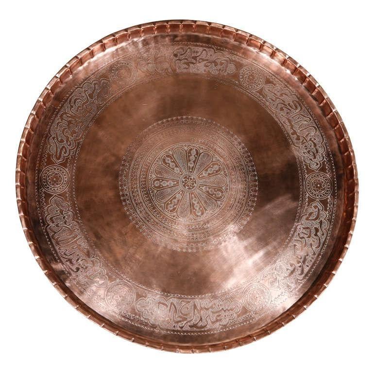 19th century Asian Turkish Mameluke style copper tray with Arabic calligraphy script writing designs.
Large antique Middle Eastern Turkish wall hanging metal tray with intricate geometric designs throughout and pie crust edges.
The metal brass
