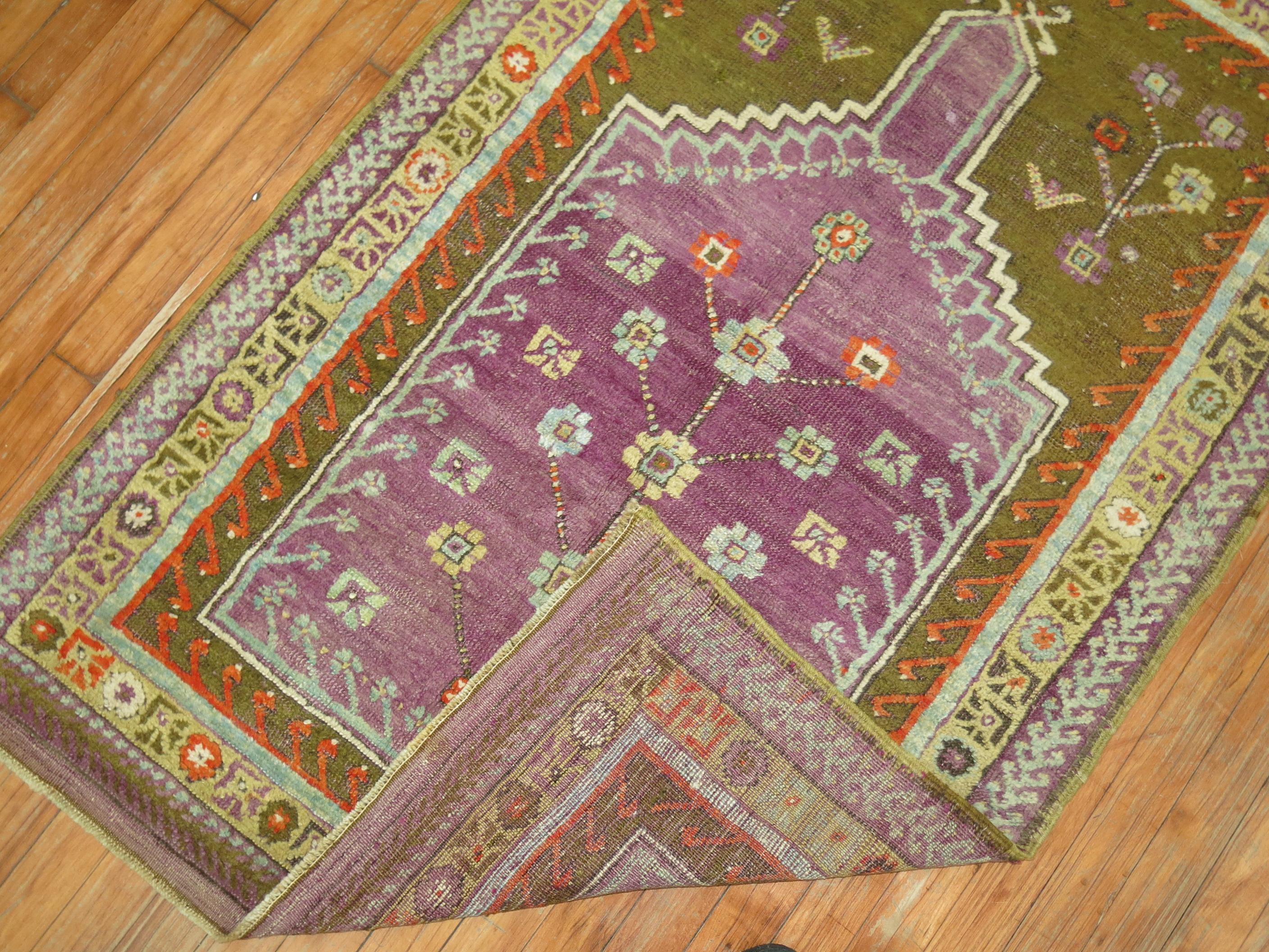 A one of a kind decorative Turkish Ghiordes rug with a prayer niche motif featuring an unusual purple color.