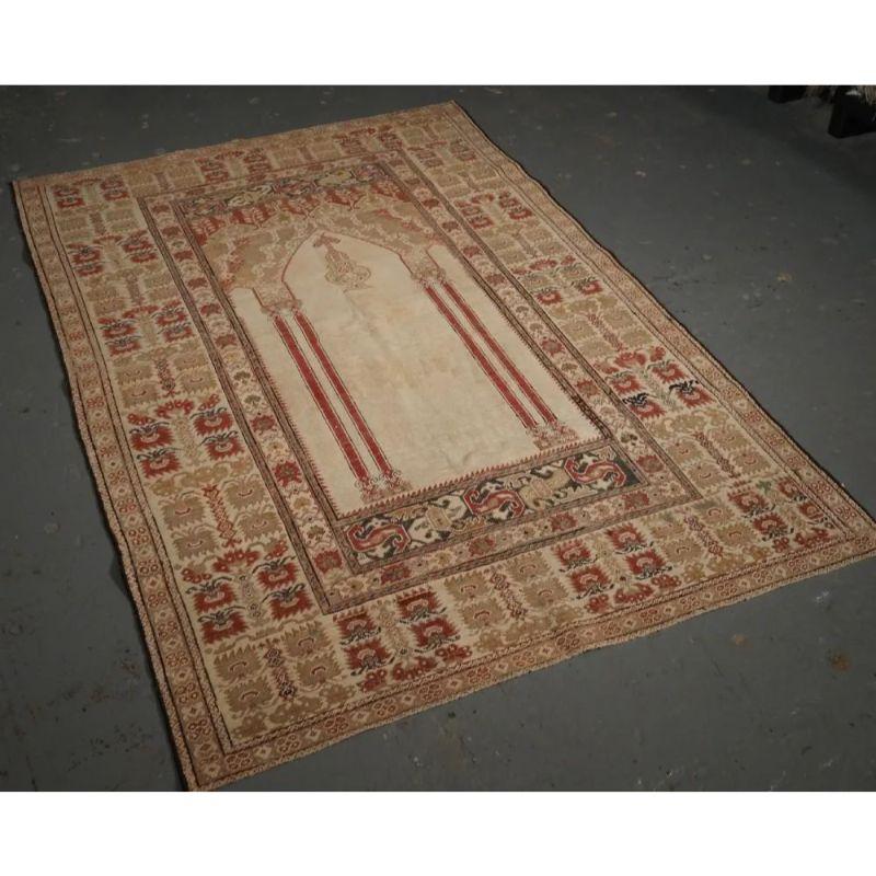 Antique Turkish Ghiordes prayer rug of classic four column design with superb colour and early date.

The rug is beautifully drawn with a white ground and soft red columns. The wide border design is very attractive. The rug is of fine