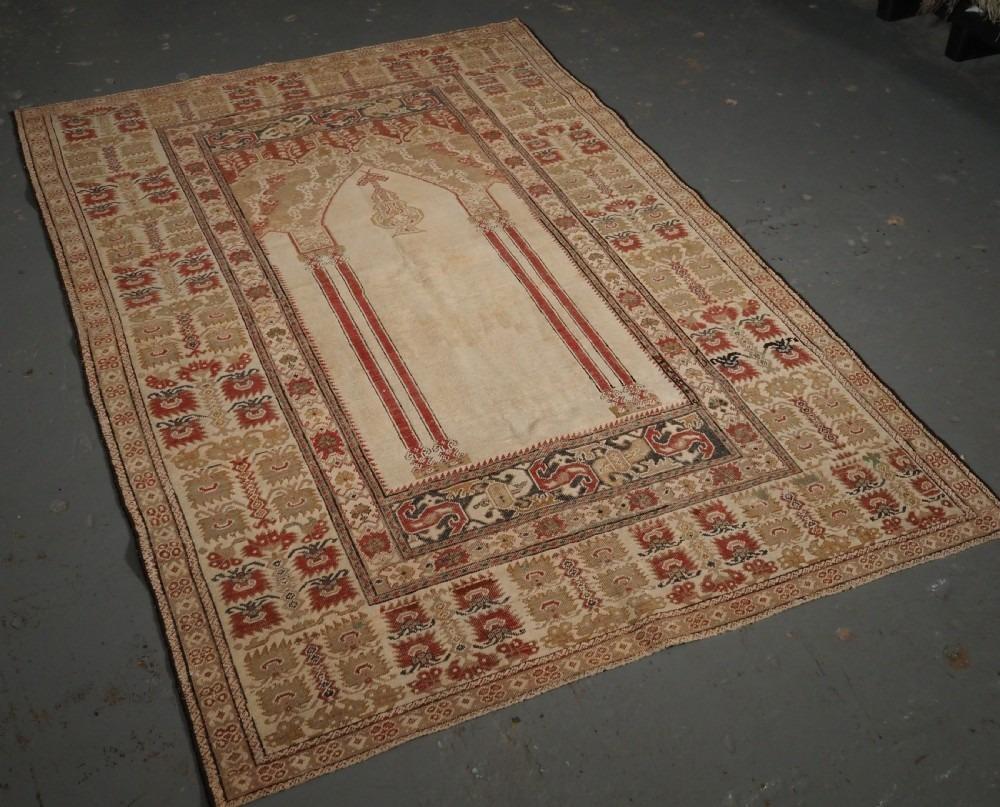 Antique Turkish Ghiordes prayer rug of classic four column design with superb colour and early date
18th century

The rug is beautifully drawn with a white ground and soft red columns The wide border design is very attractive The rug is of fine