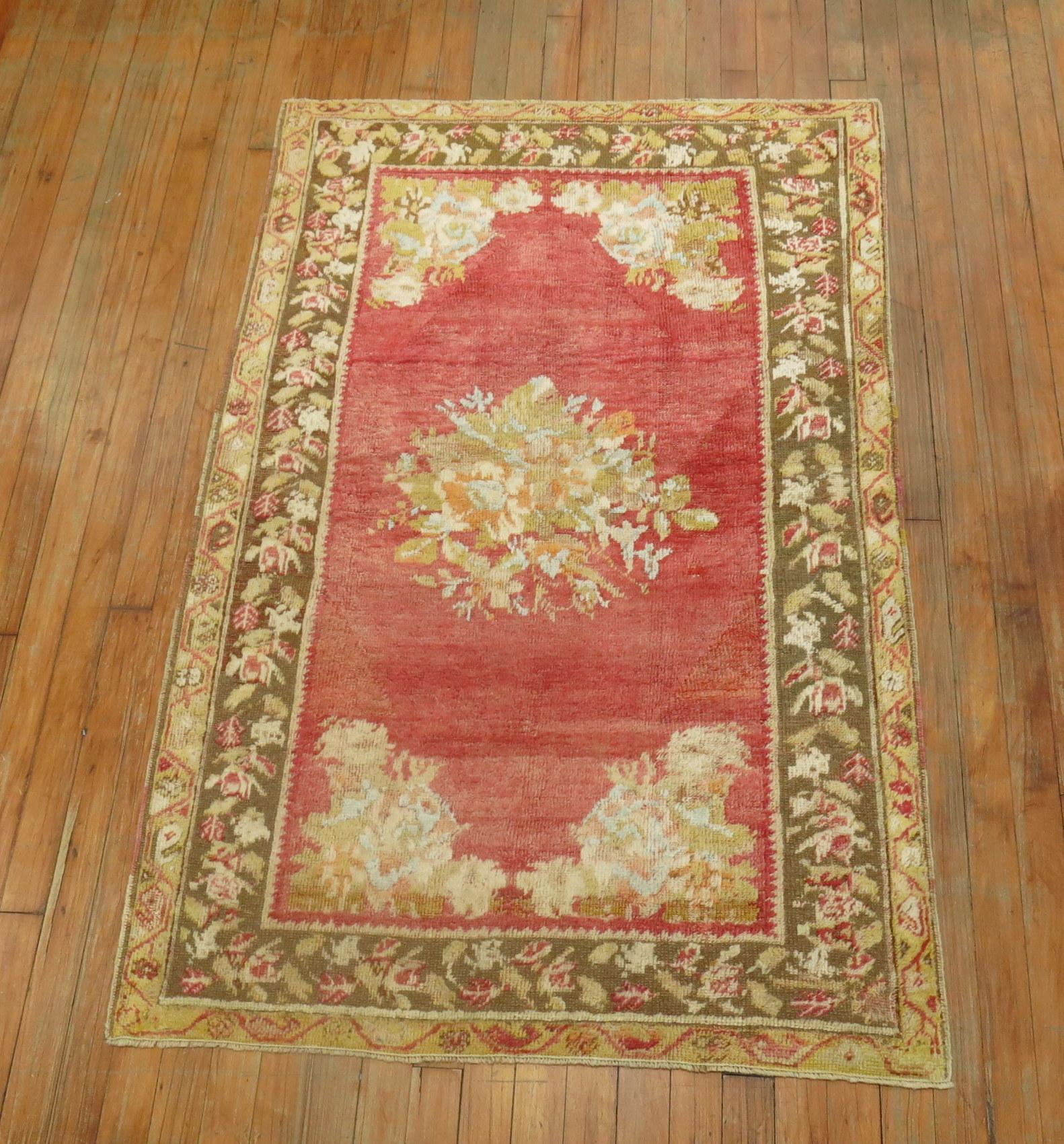 Magnifique tapis ghiordes turc ancien aux couleurs douces, avec un motif floral en médaillon ouvert et une bordure florale.