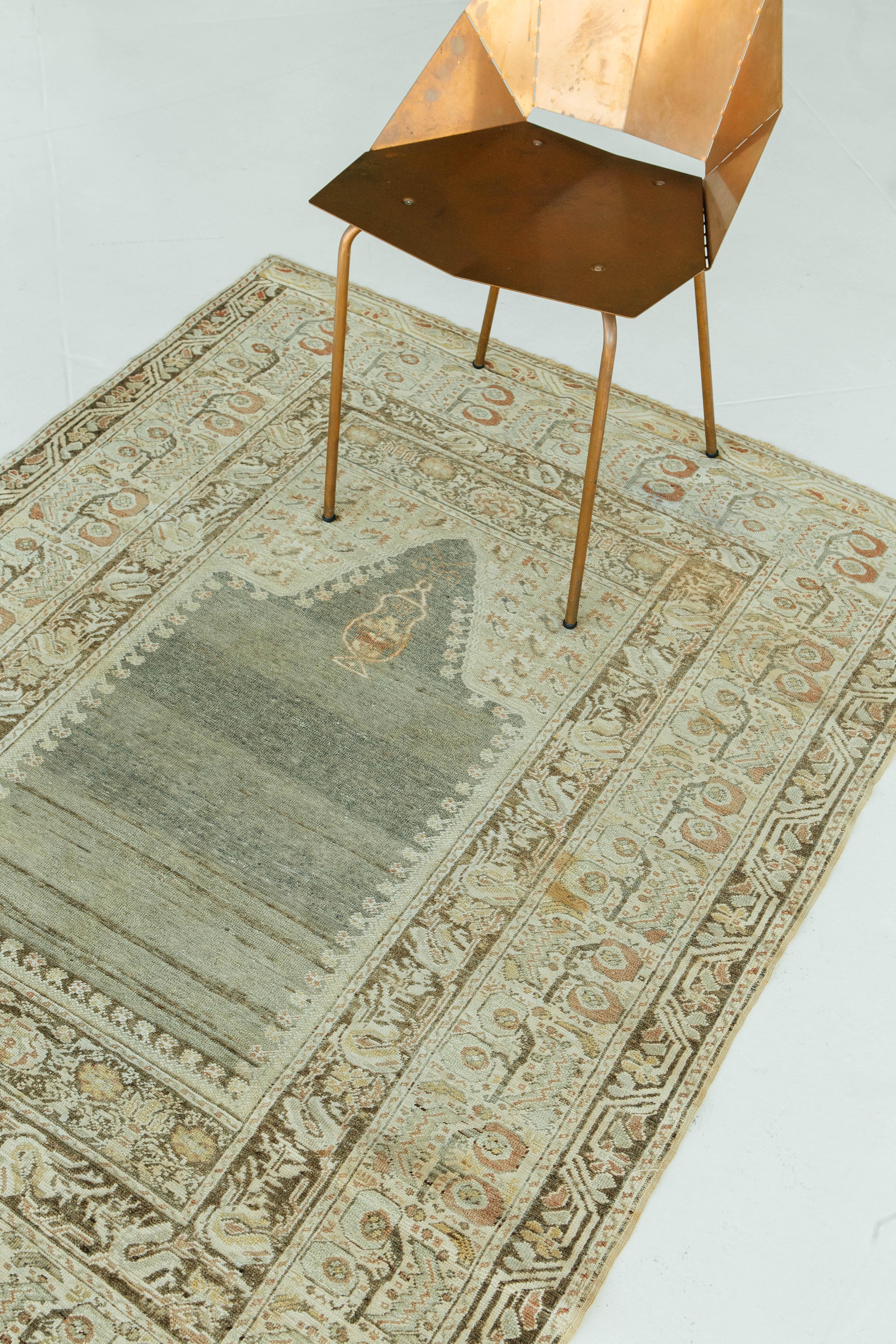 Brown, gray, green, and neutral toned antique Turkish Gordes rug. The handmade and authentic vintage piece is constructed out of wool and features pile weave construction. Design motifs include medallion, traditional, and directional